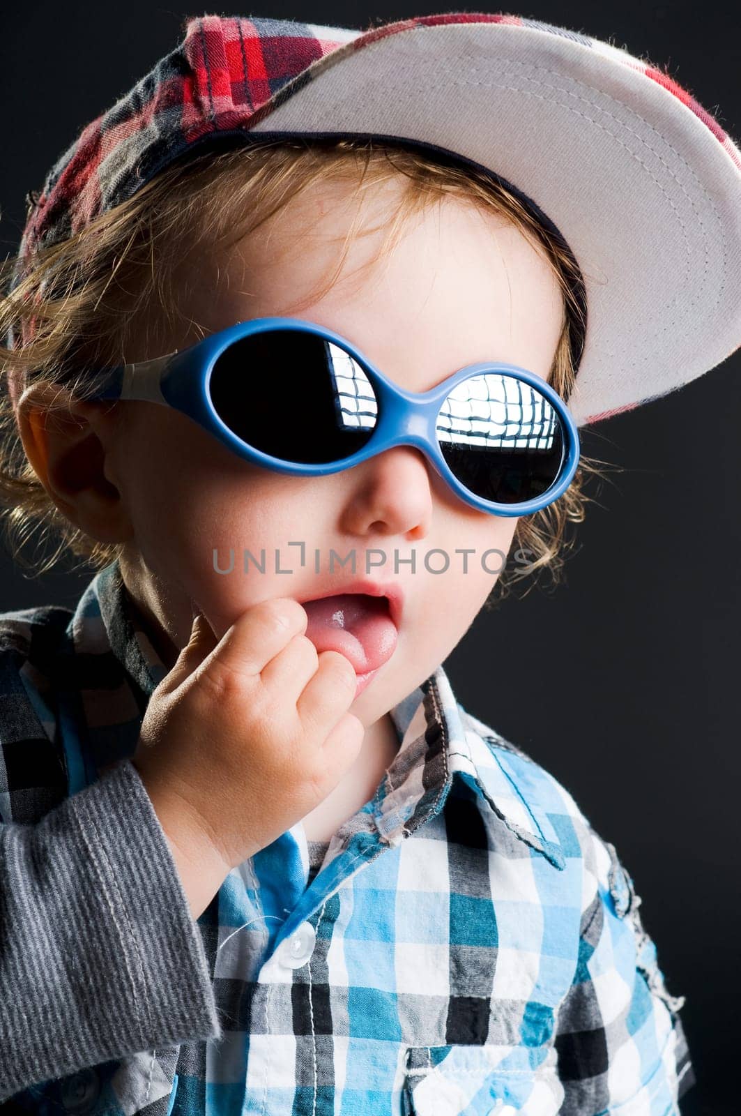 Casual cool young kid with cap and sunglasses