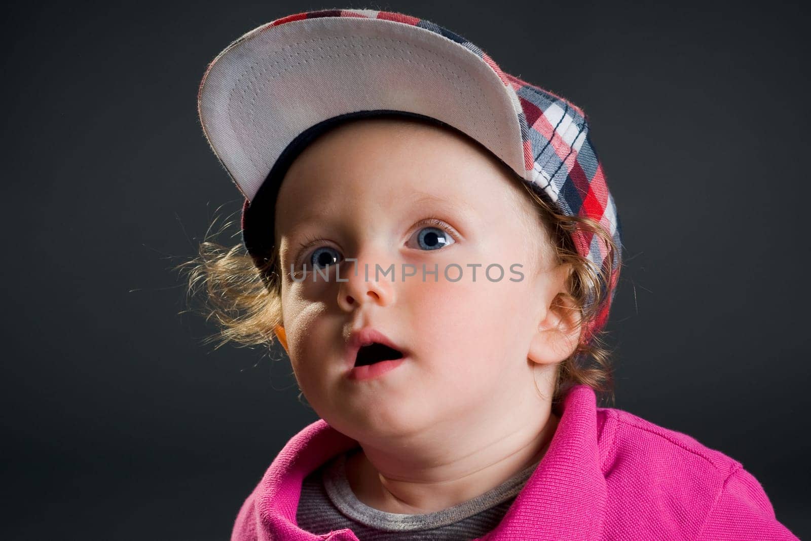 Casual cool young kid with cap against gray background