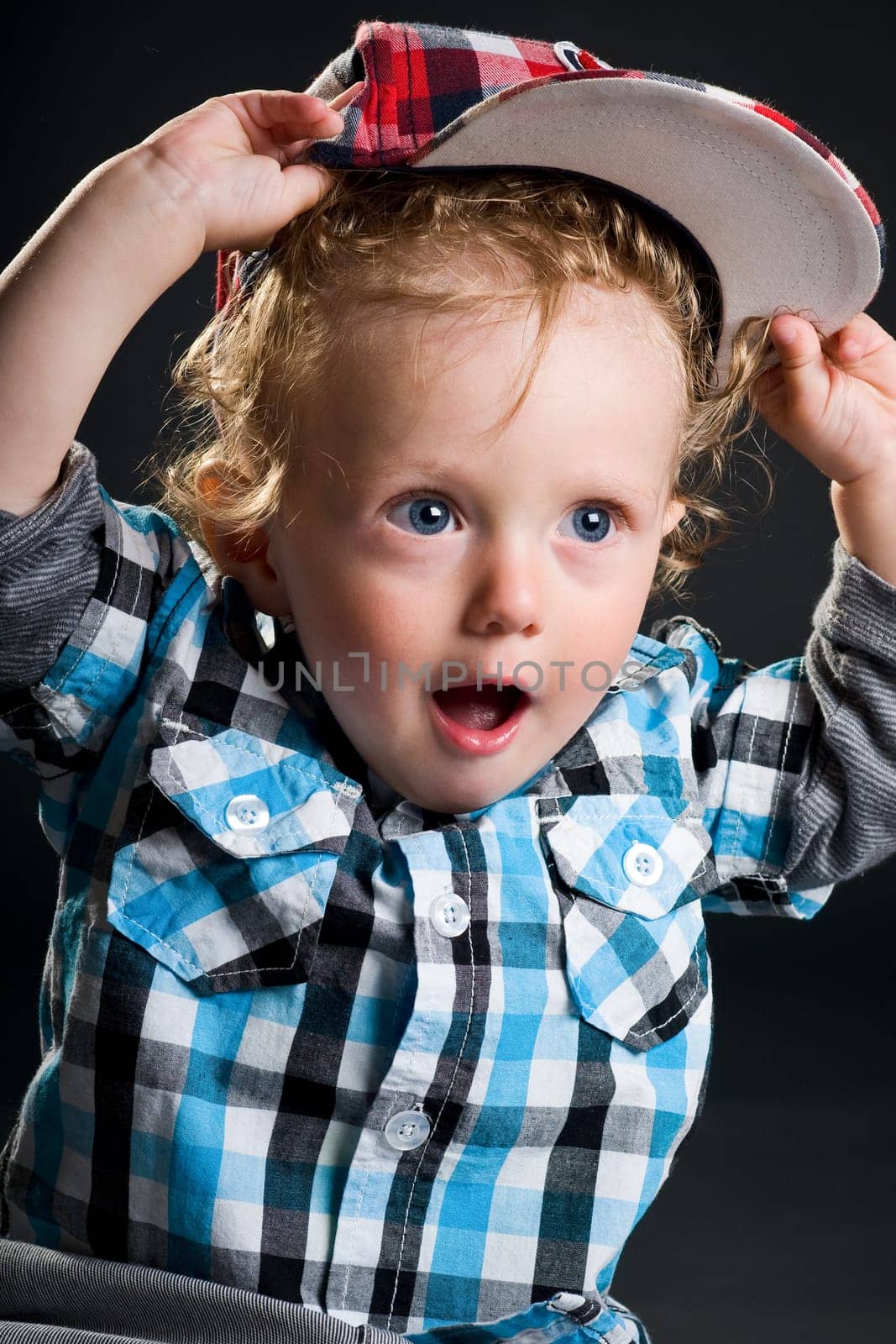 Casual cool young kid with cap against gray background
