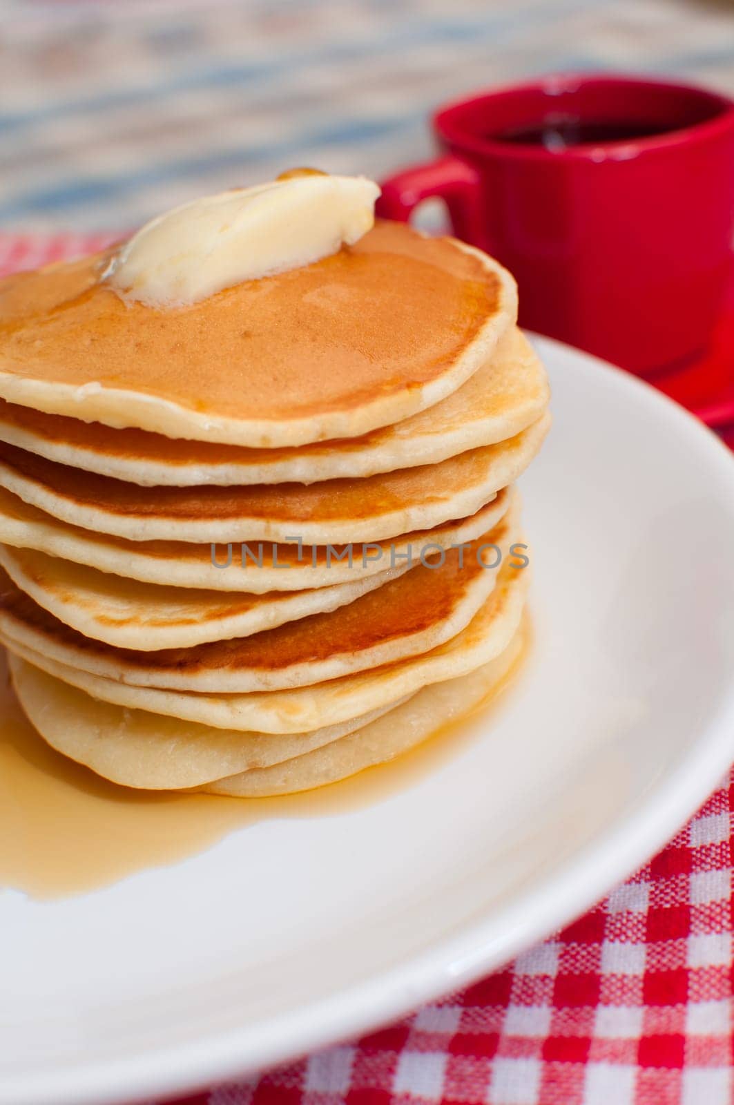 Pancakes With Butter and Warm Maple Syrup On The Table