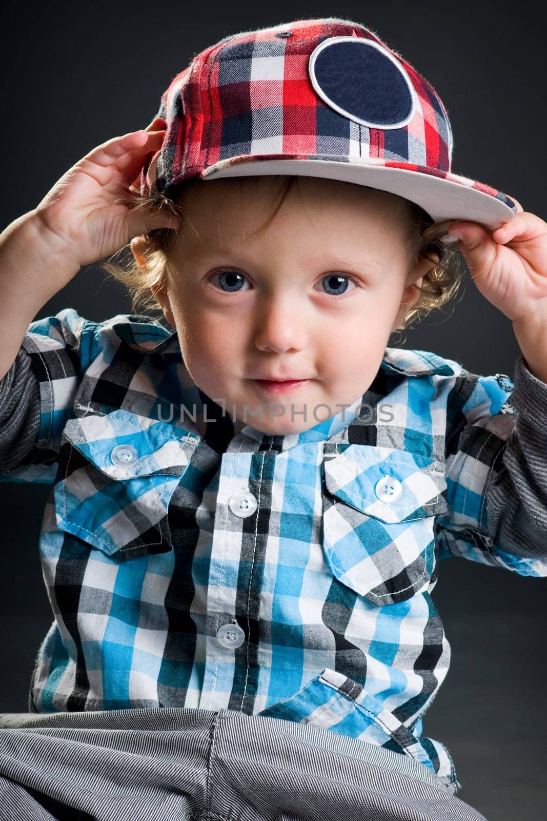 Casual cool young kid with cap against gray background