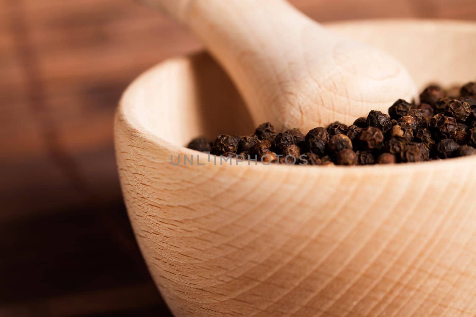 Close-up of peppercorns in a wooden mortar