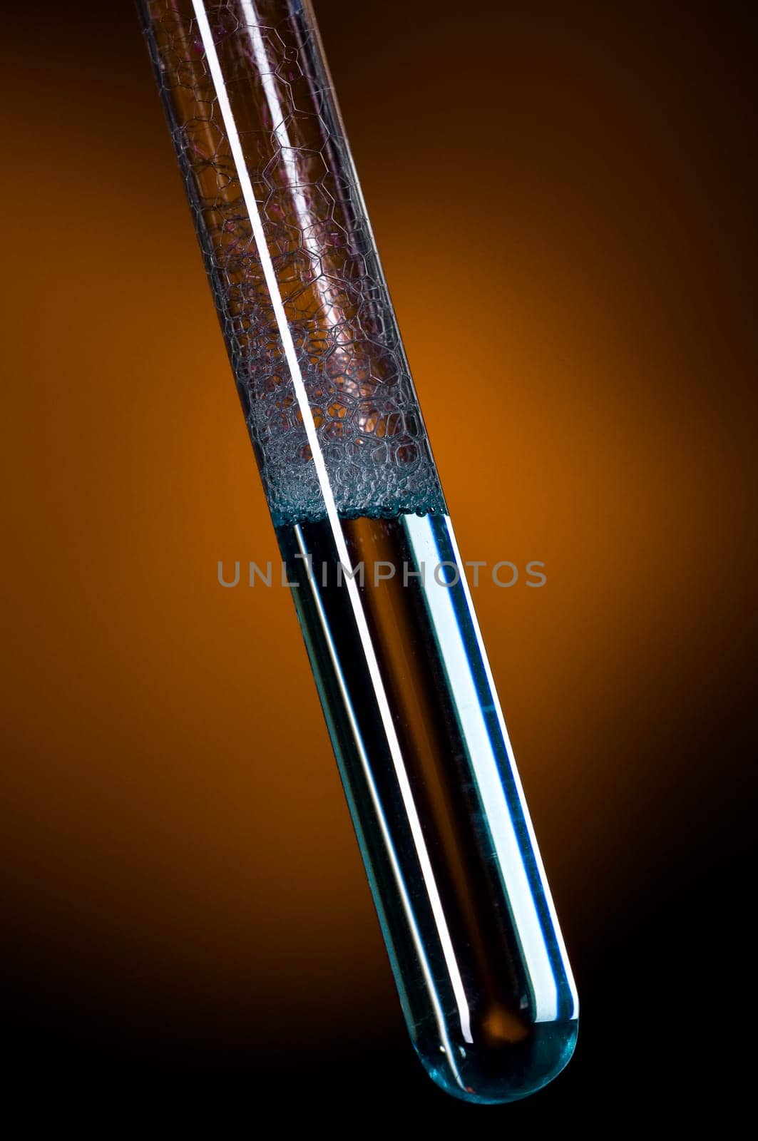 Glass test tube filled with liquid and foam