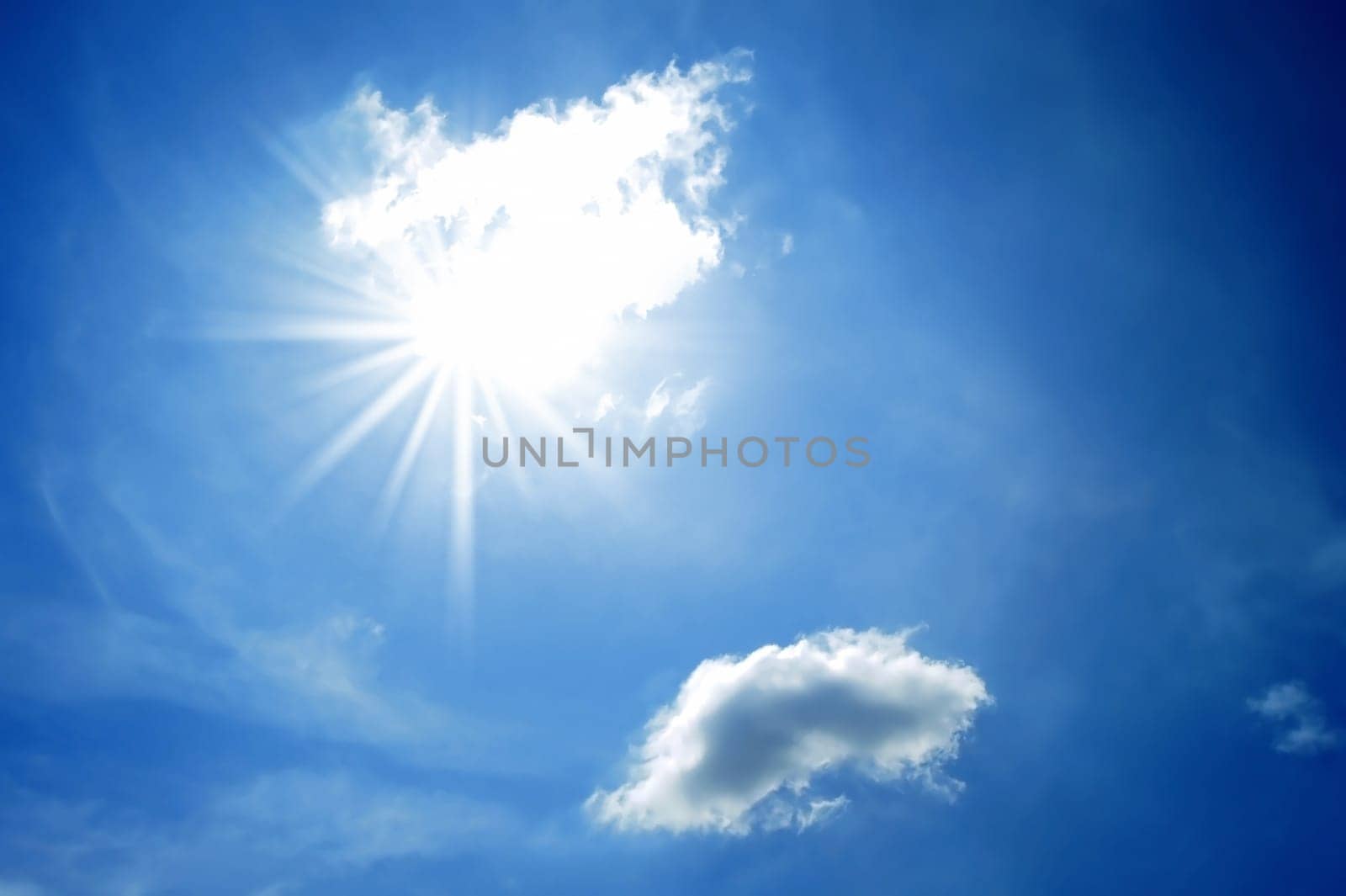 Sun and a small cloud in the blue sky