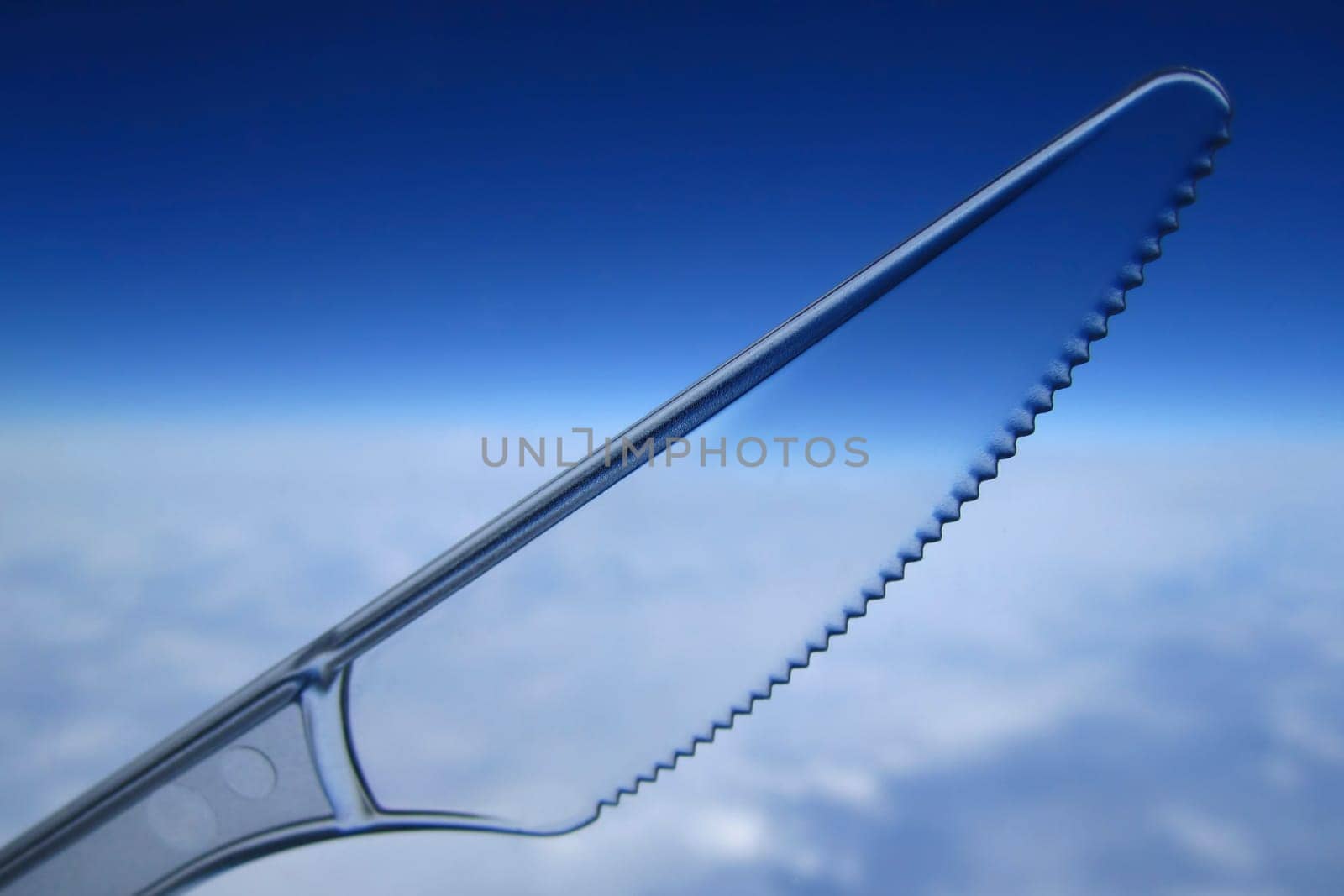 Clear plastic disposable knife against the sky