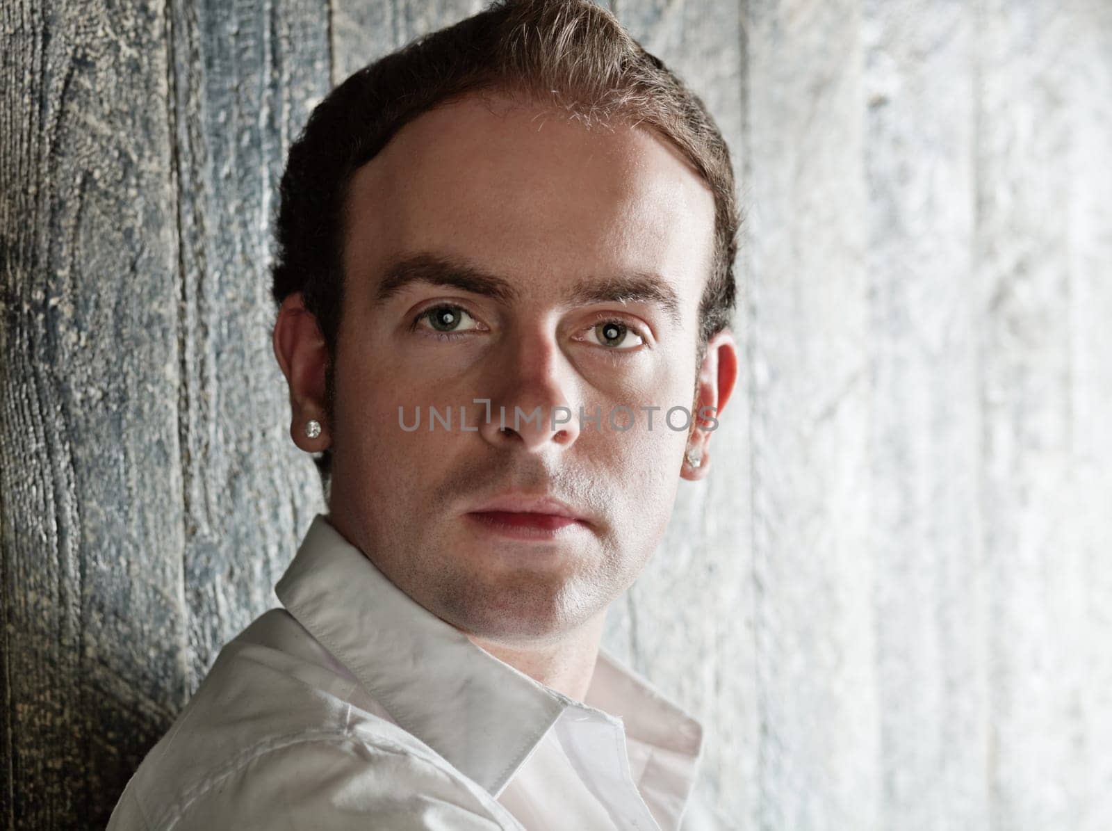 Portrait of serious young handsome man with earrings