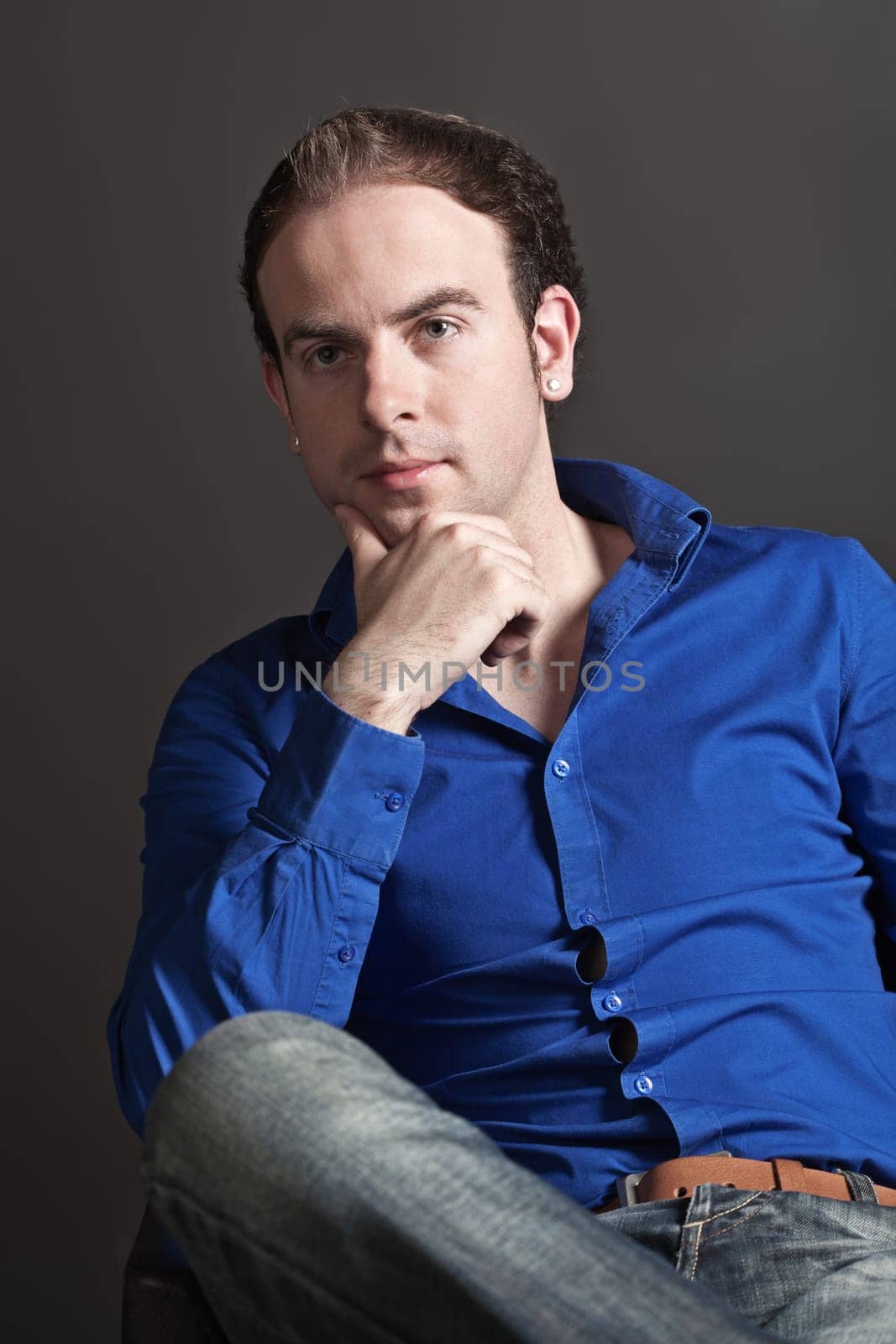 Portrait of a pensive young handsome man touching his chin