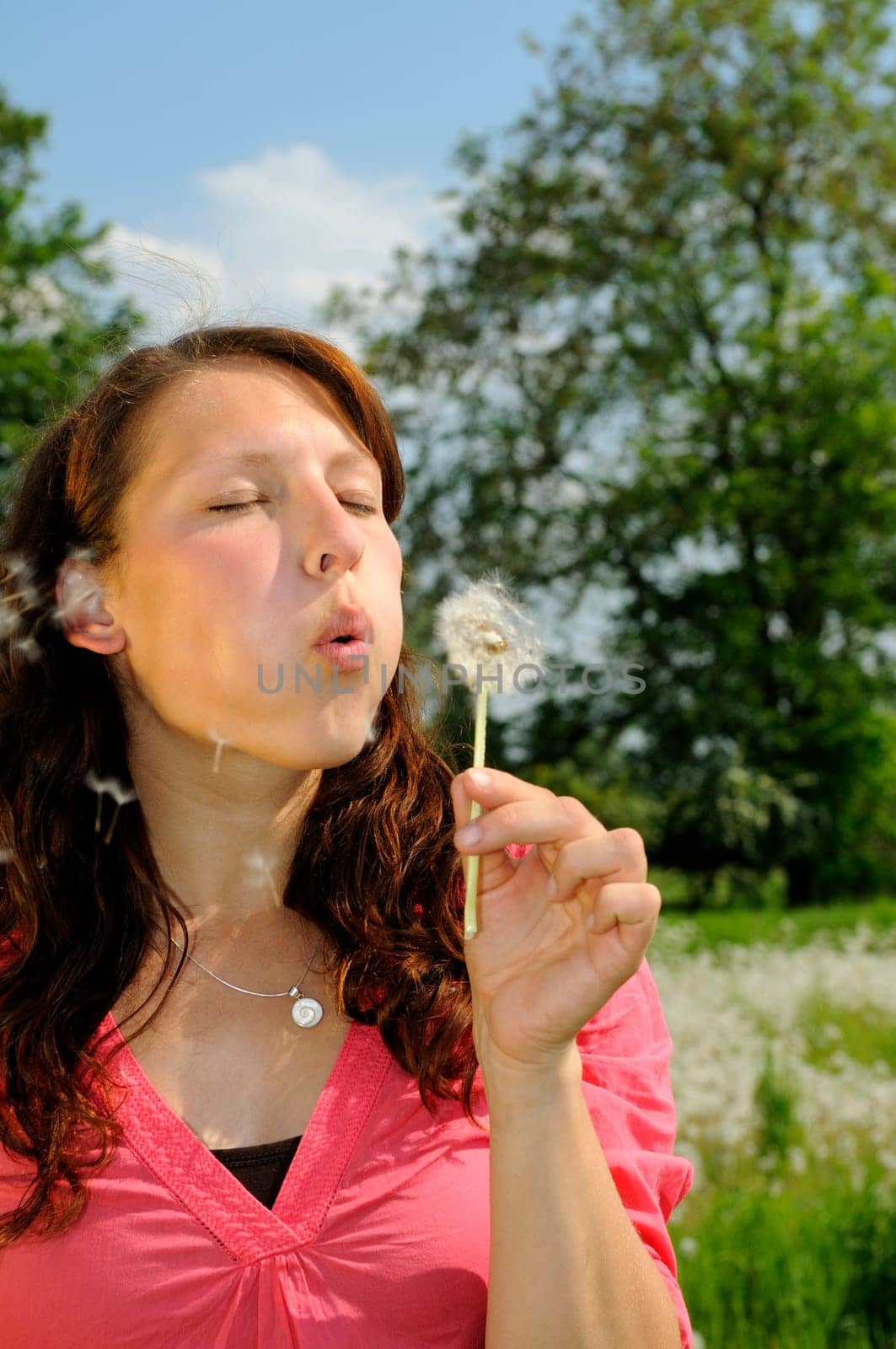 Young woman with dandelion