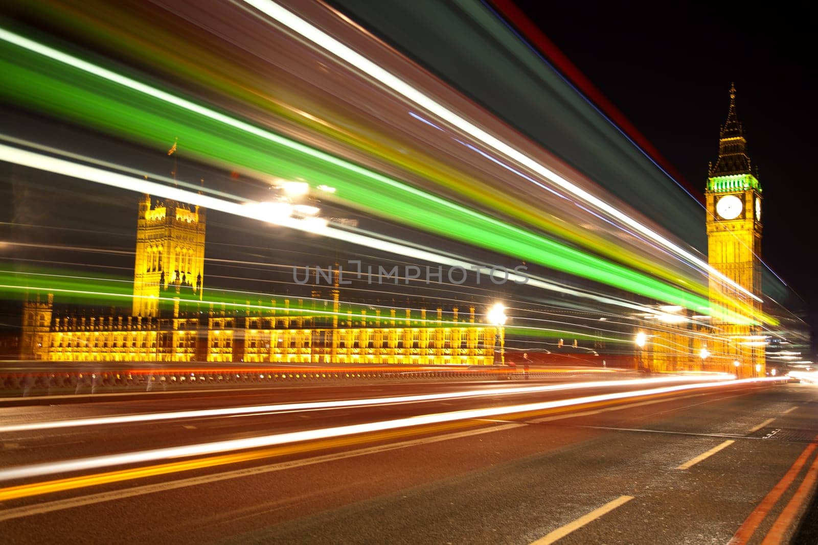 Big Ben and Houses of Parliament in London with lights effect from incoming bus