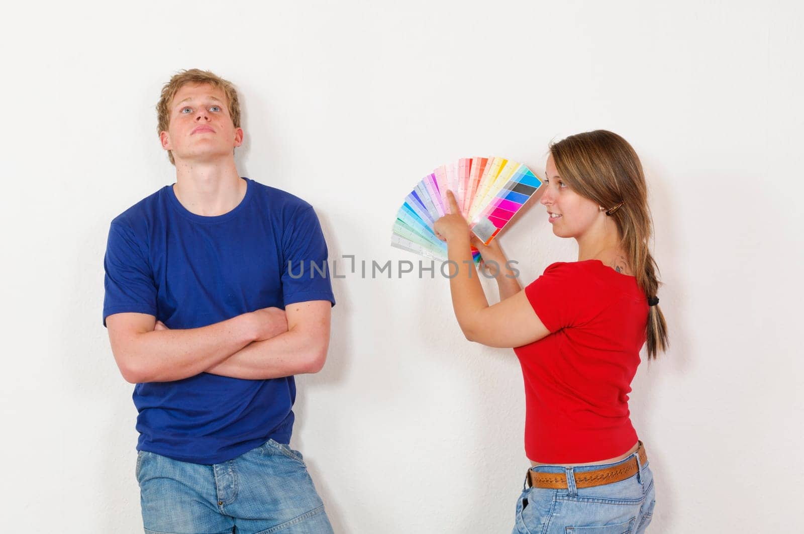 A young attractive couple renovate the stress and the first joint home. They holding a color chart and are looking out for the new wall colour.