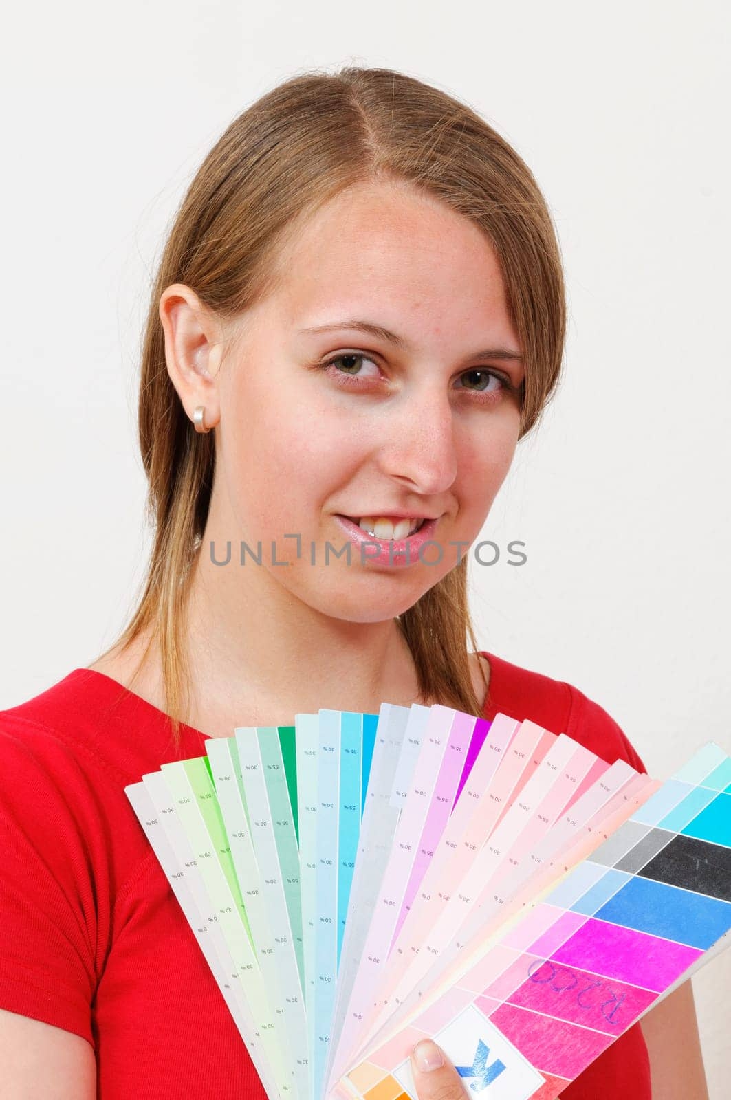 Young woman in colorful t-shirt holding a color fan and smiling