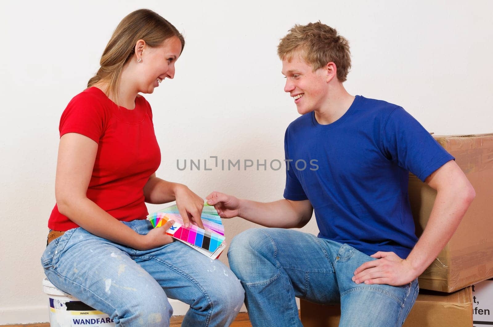 A young attractive couple renovate the stress and the first joint home. They holding a color chart and are looking out for the new wall colour.