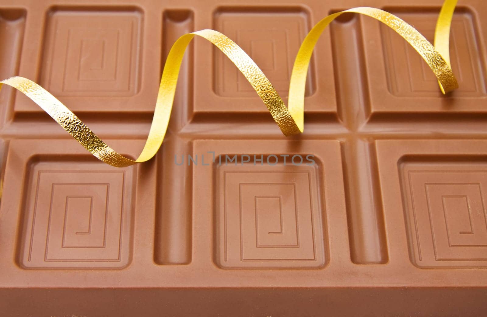 Background of fine Belgian chocolate with festive ribbons for the celebration of a special day.