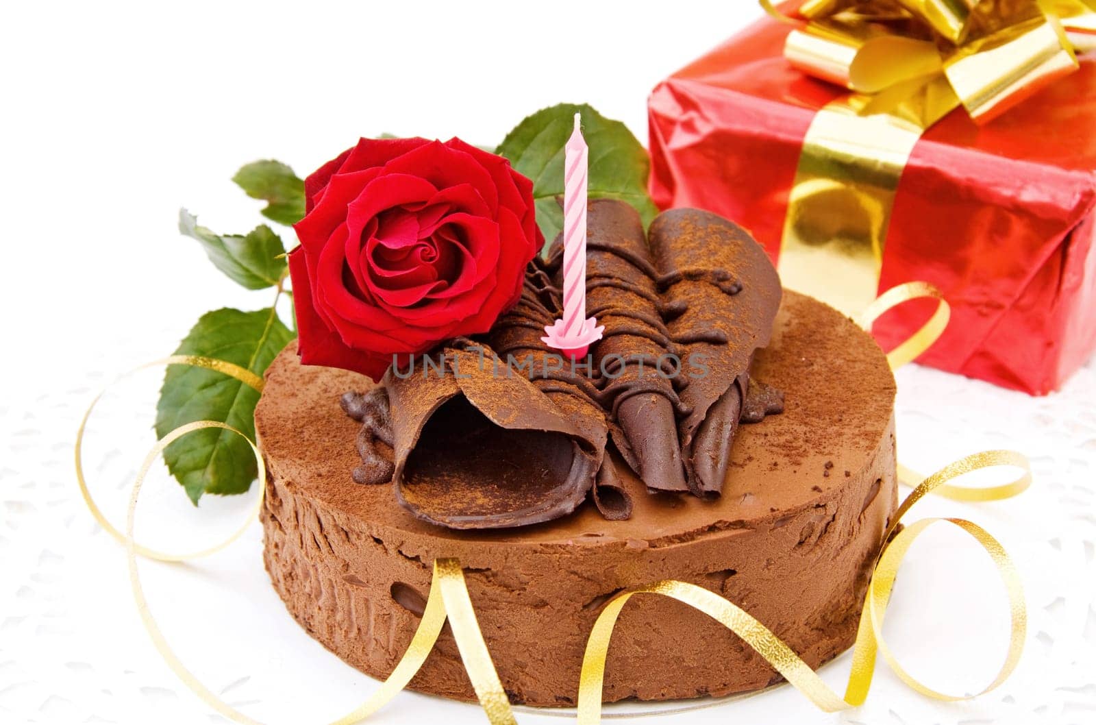 Celebrating birthdays with delicious toffee cake, red rose and gifts. Isolated on white background.
