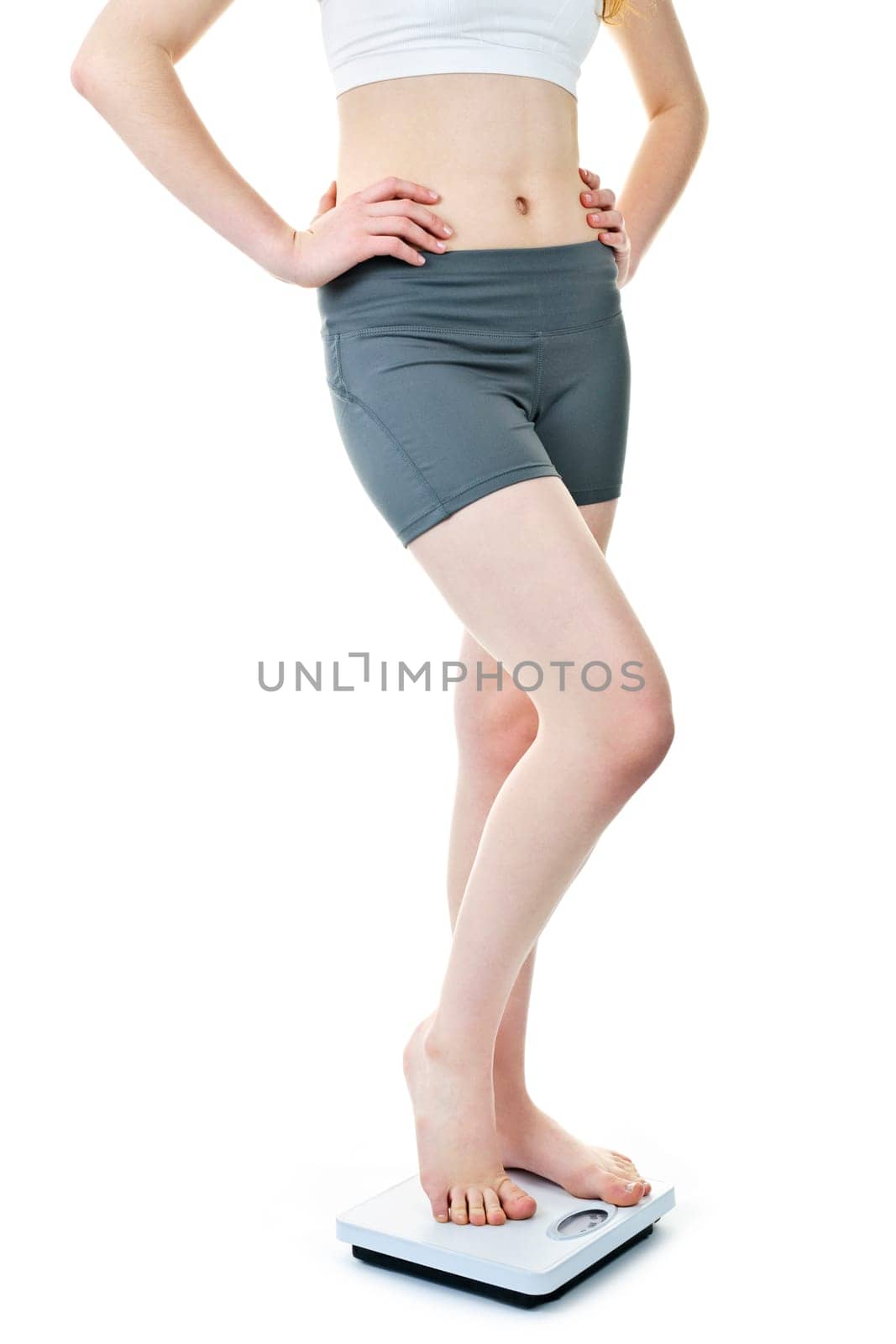 Healthy young woman standing on bathroom scale isolated on white
