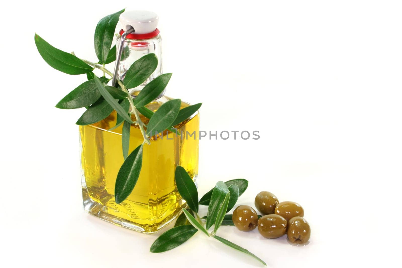 a bottle of olive oil with olive branch and olives