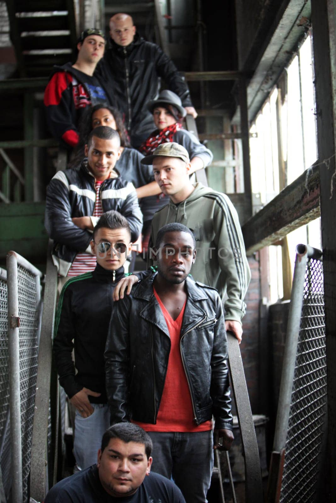 Portrait of a group of nine young people. They stand one behind the other on a staircase