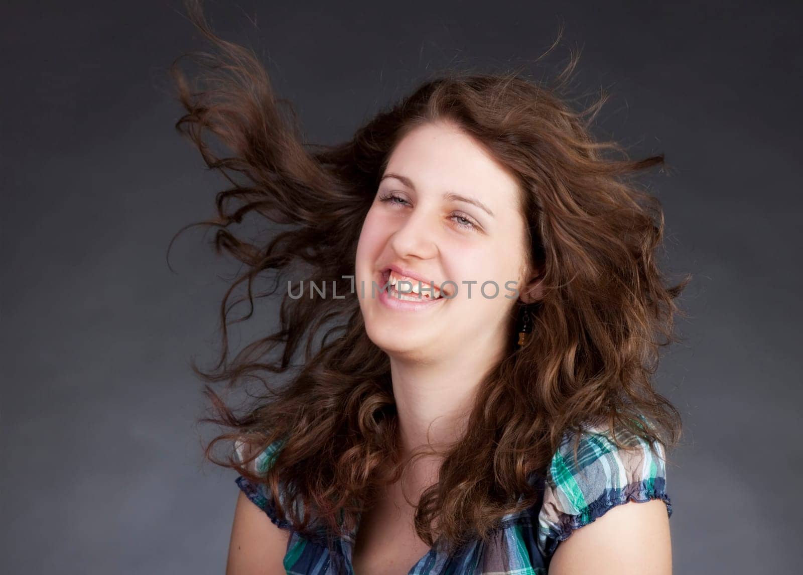 young brunette woman with long flying hair, studio shot