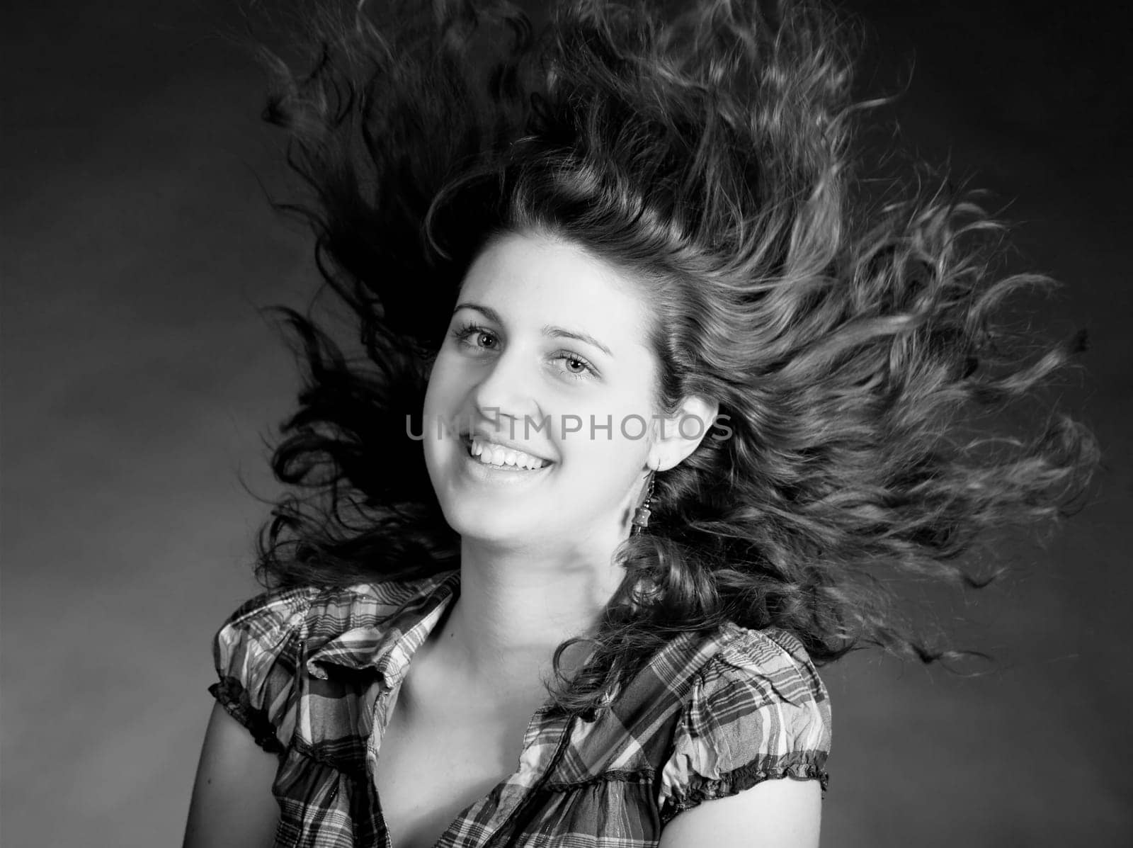 young brunette woman with long flying hair, studio shot