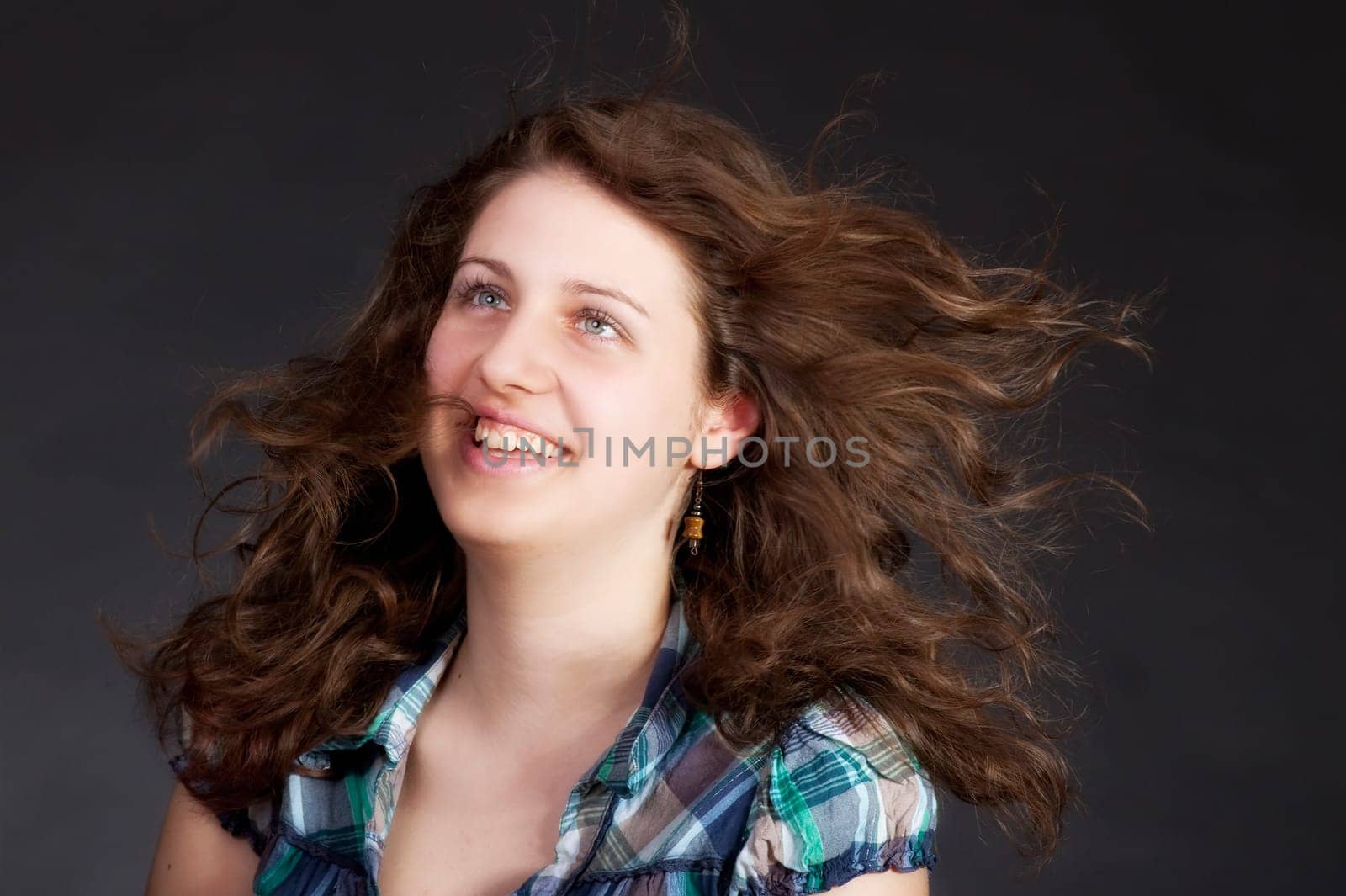 young brunette woman with long flying hair, studio shot