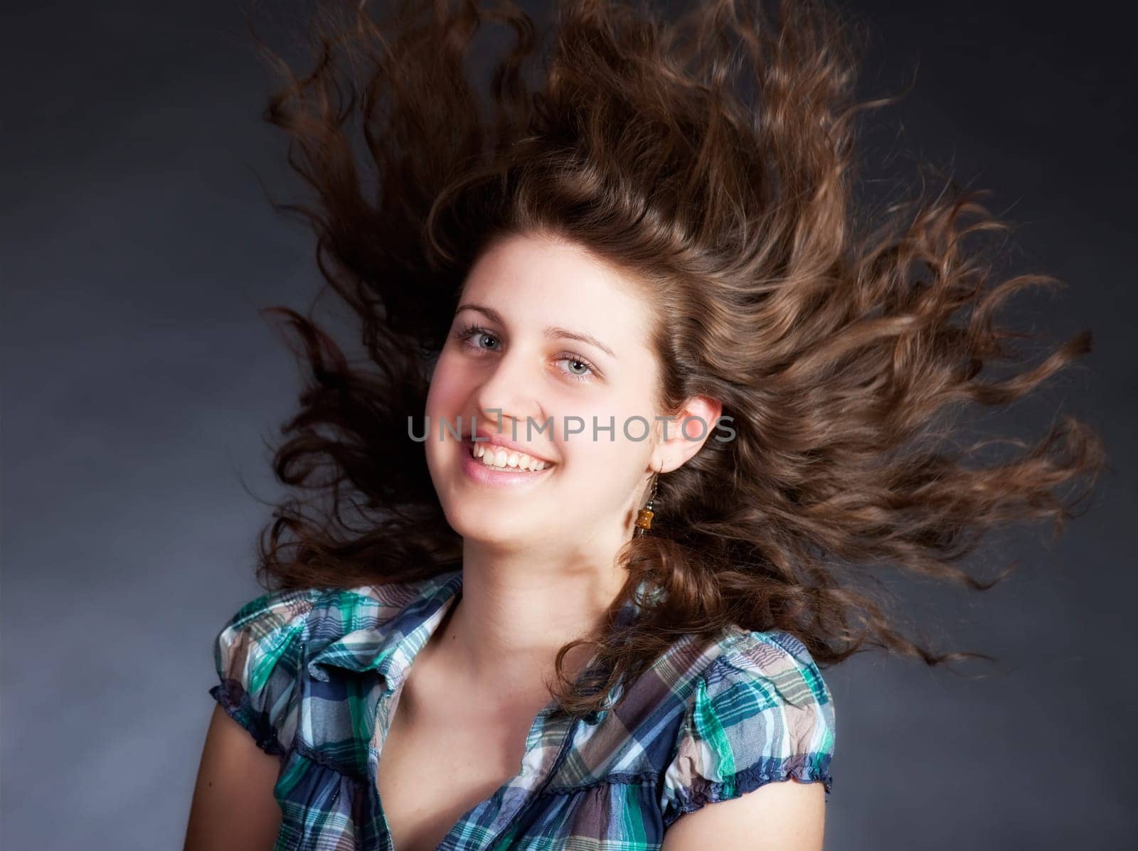 young brunette woman with long flying hair, studio shot