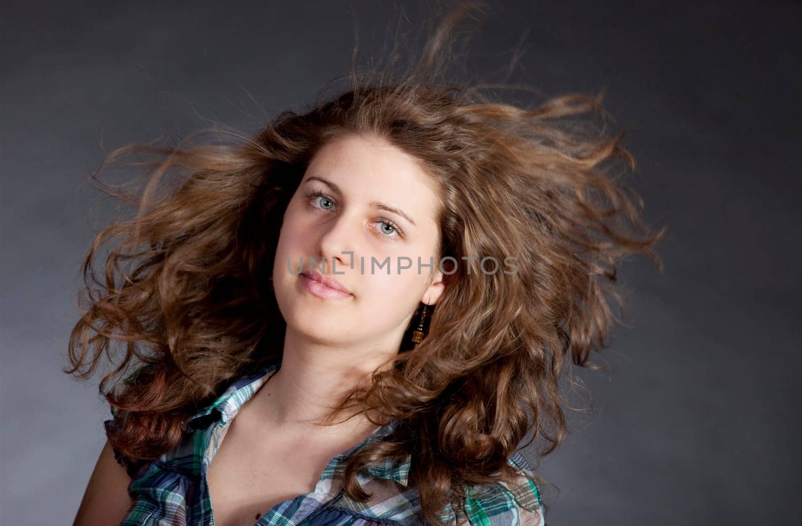 young brunette woman with long flying hair, studio shot