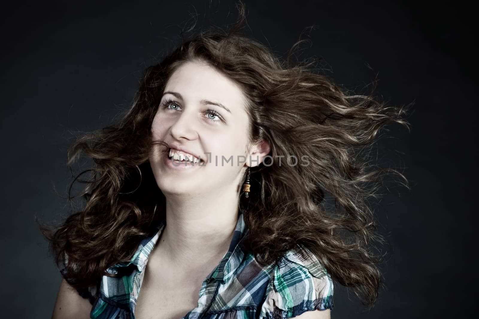 young brunette woman with long flying hair, studio shot