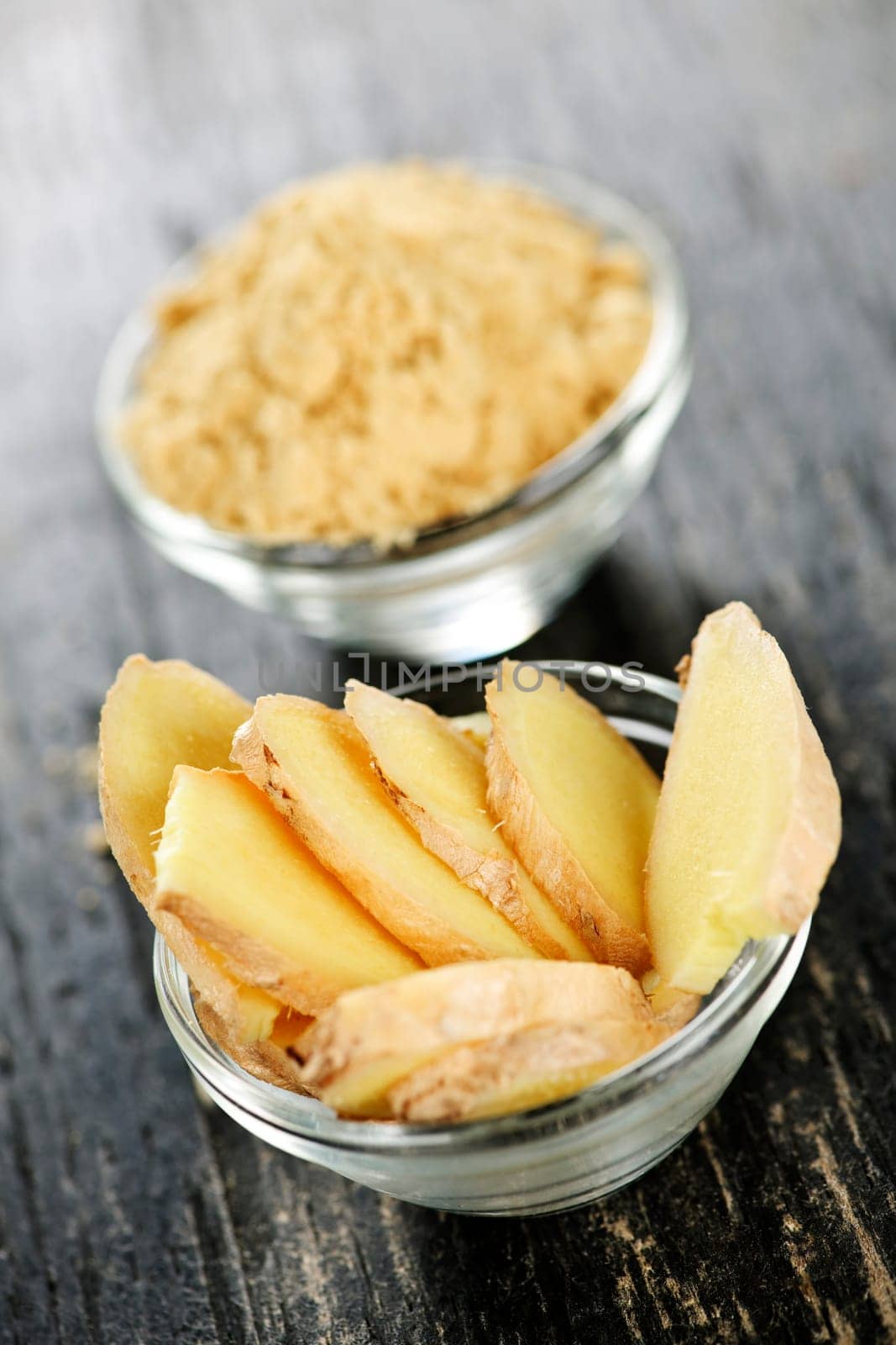 Sliced and ground fresh ginger root spice in glass bowls