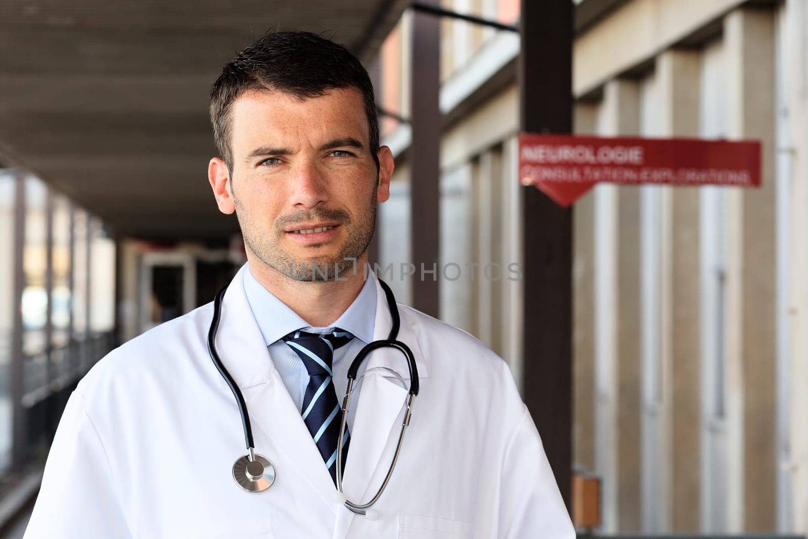 young doctor with stethoscope in hospital hall