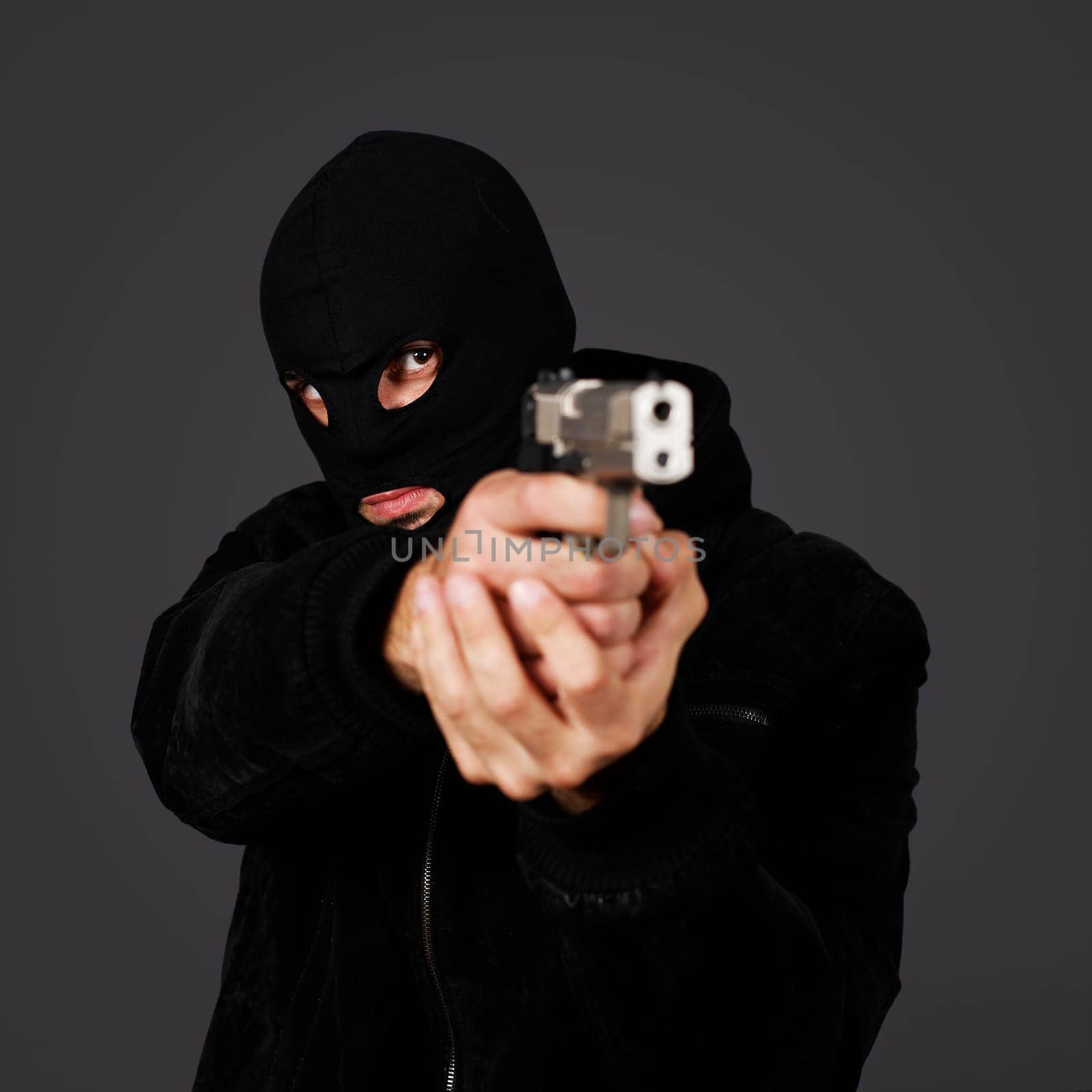 black dressed man with gun in studio