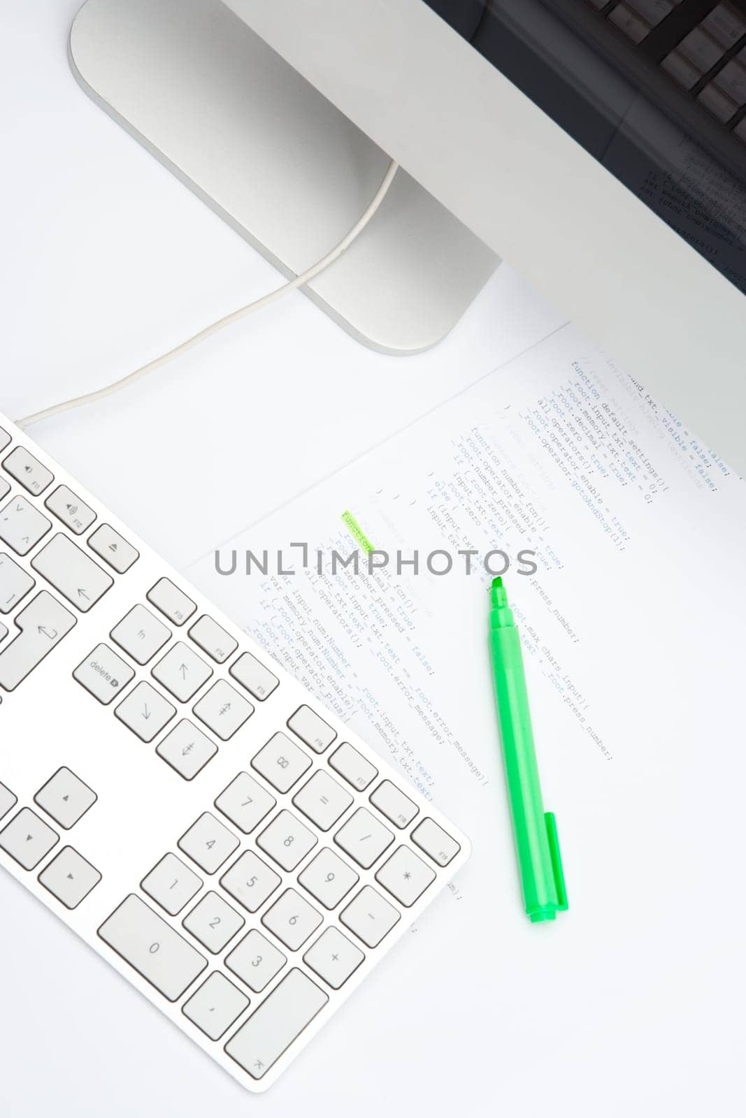 Programmer workplace - printed code with highlighter and computer