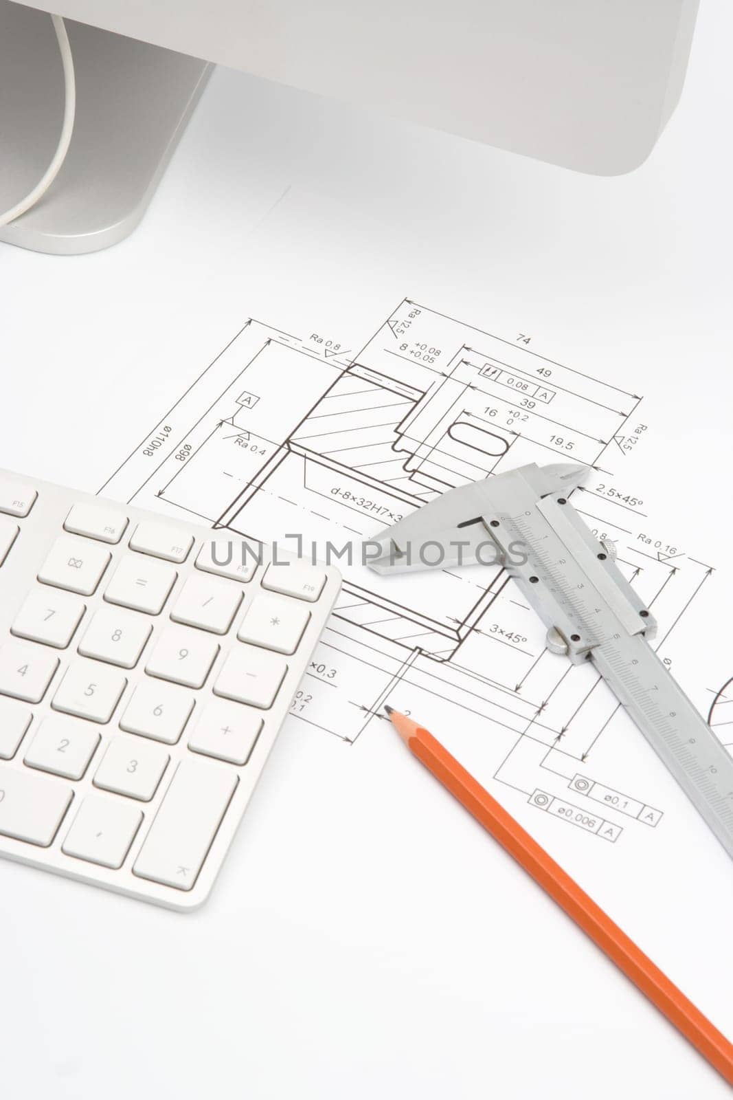 Mechanical engineer workplace - blueprint of gearwheel, caliper, pencil and part of computer