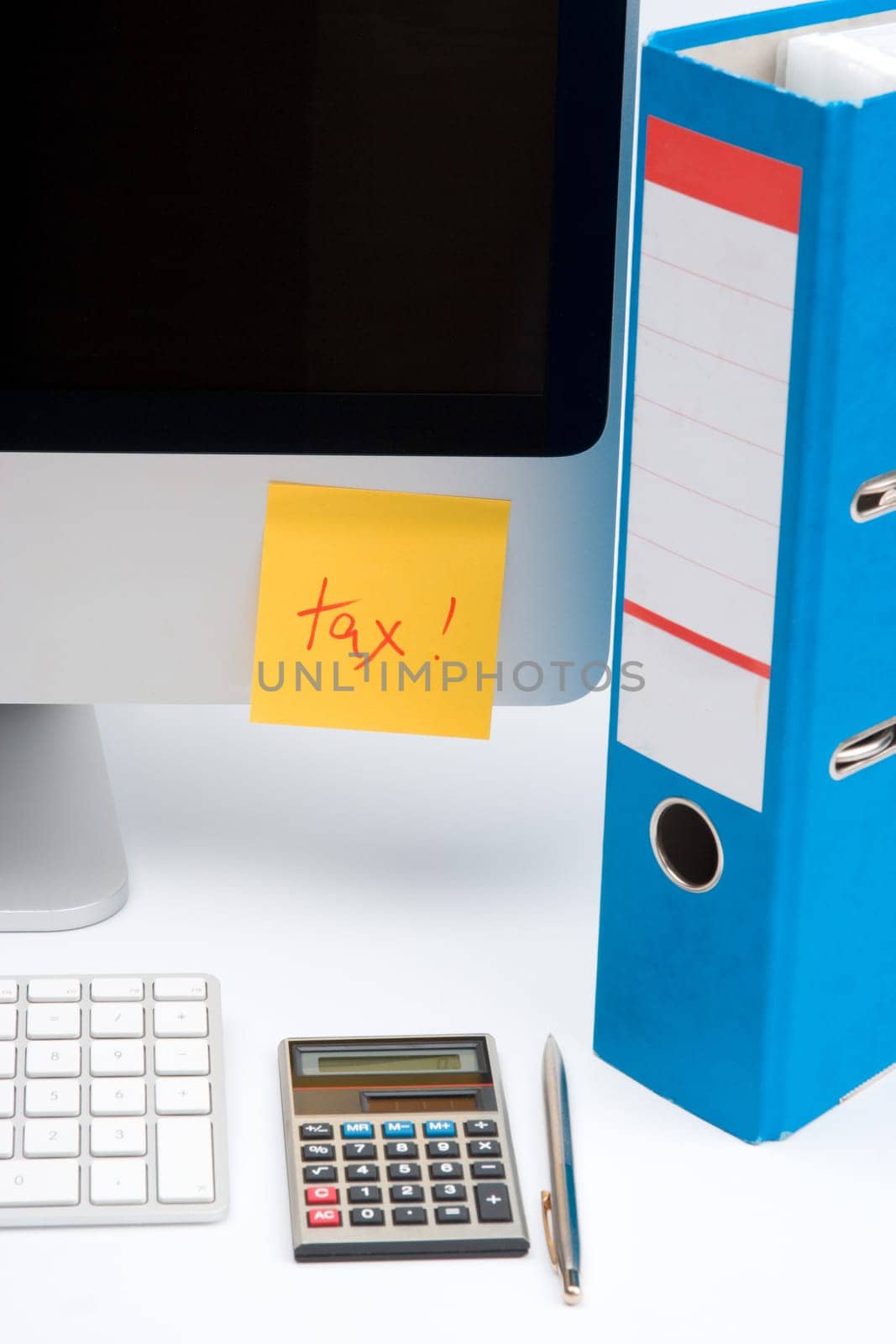Tax concept - sticky notes with word tax, part of computer, keyboard, calculator, office folder and pen