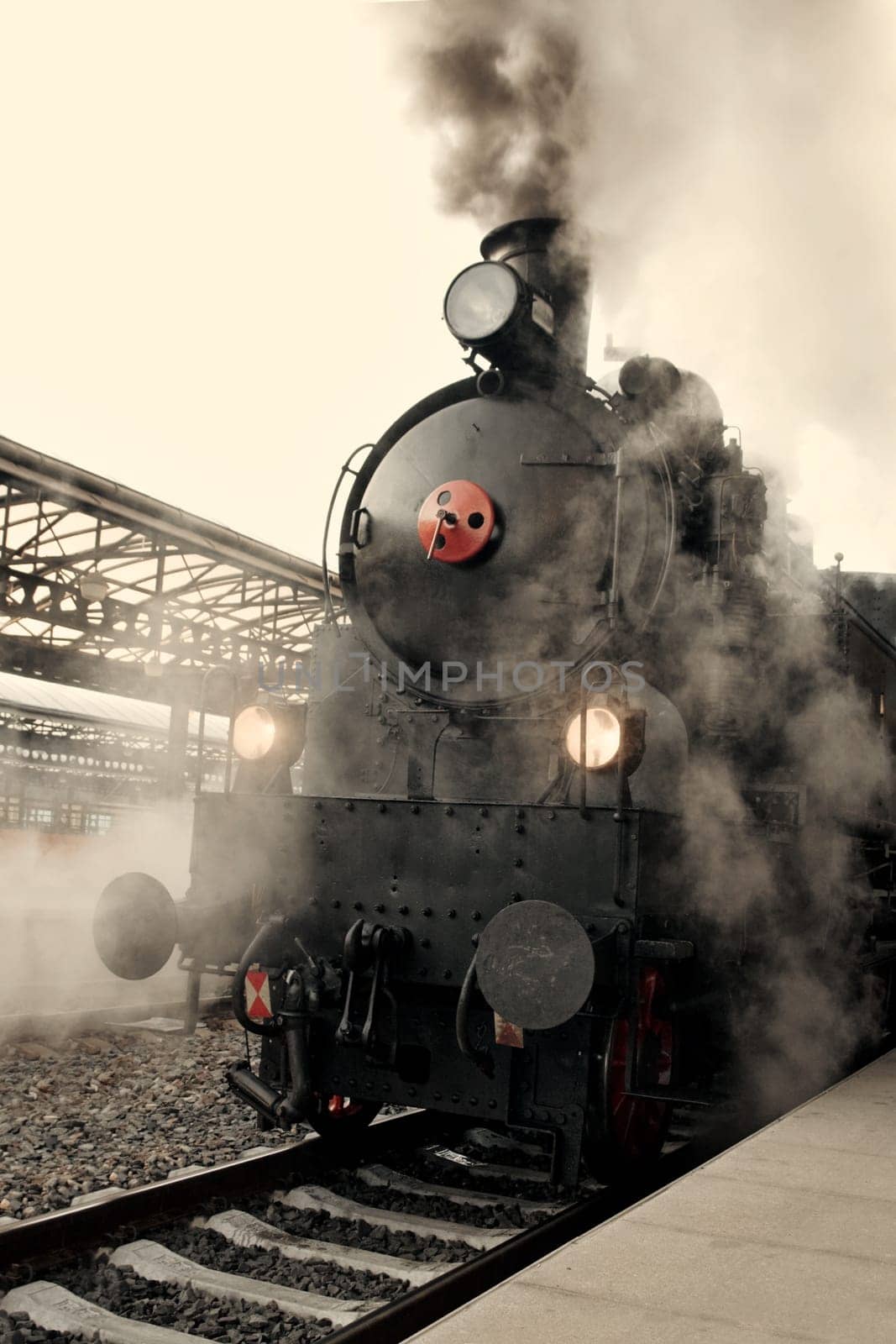 Steam locomotive at the railway station wrapped up in cloud - vintage retro tinting