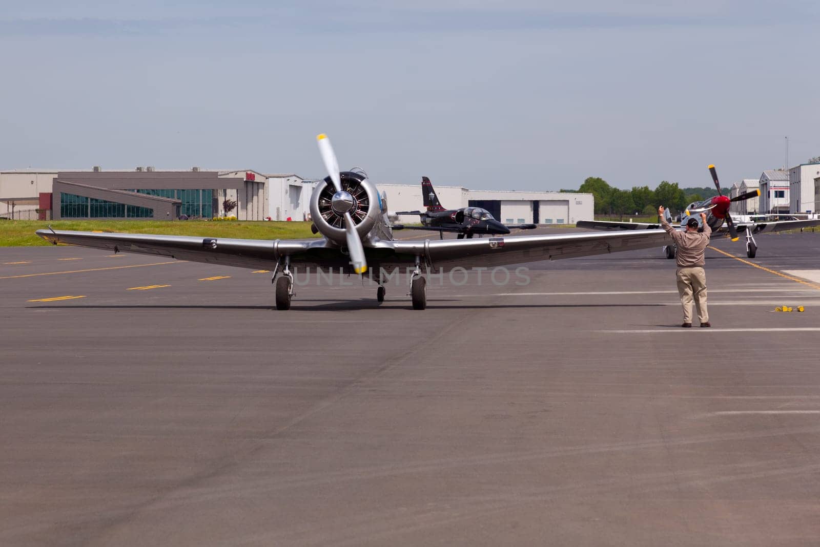 AT-6 Texan, known as the Harvard training plane leads Mustang and Albatros to runway