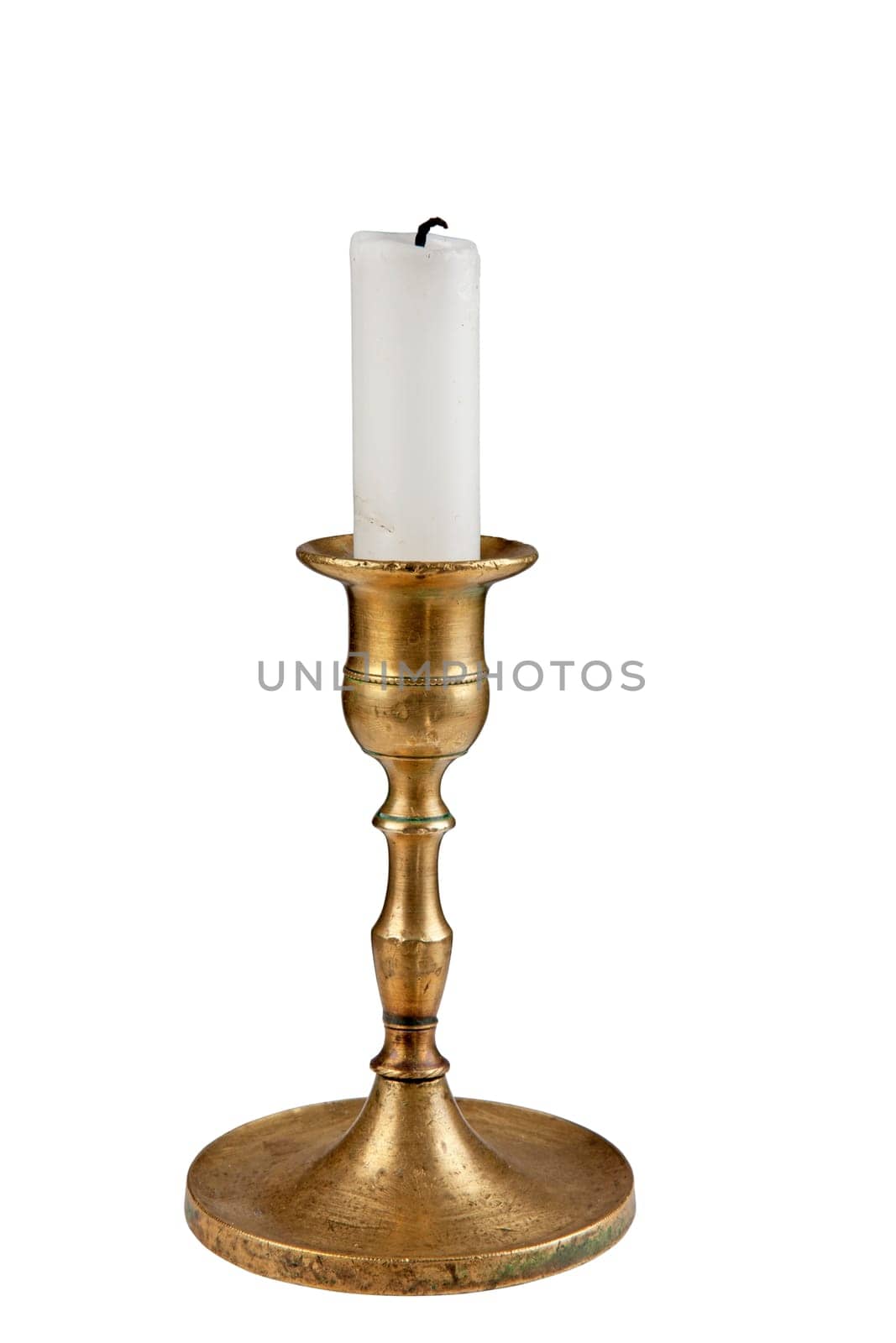 Antique brass candle holder with white pillar candle. Isolated over white.