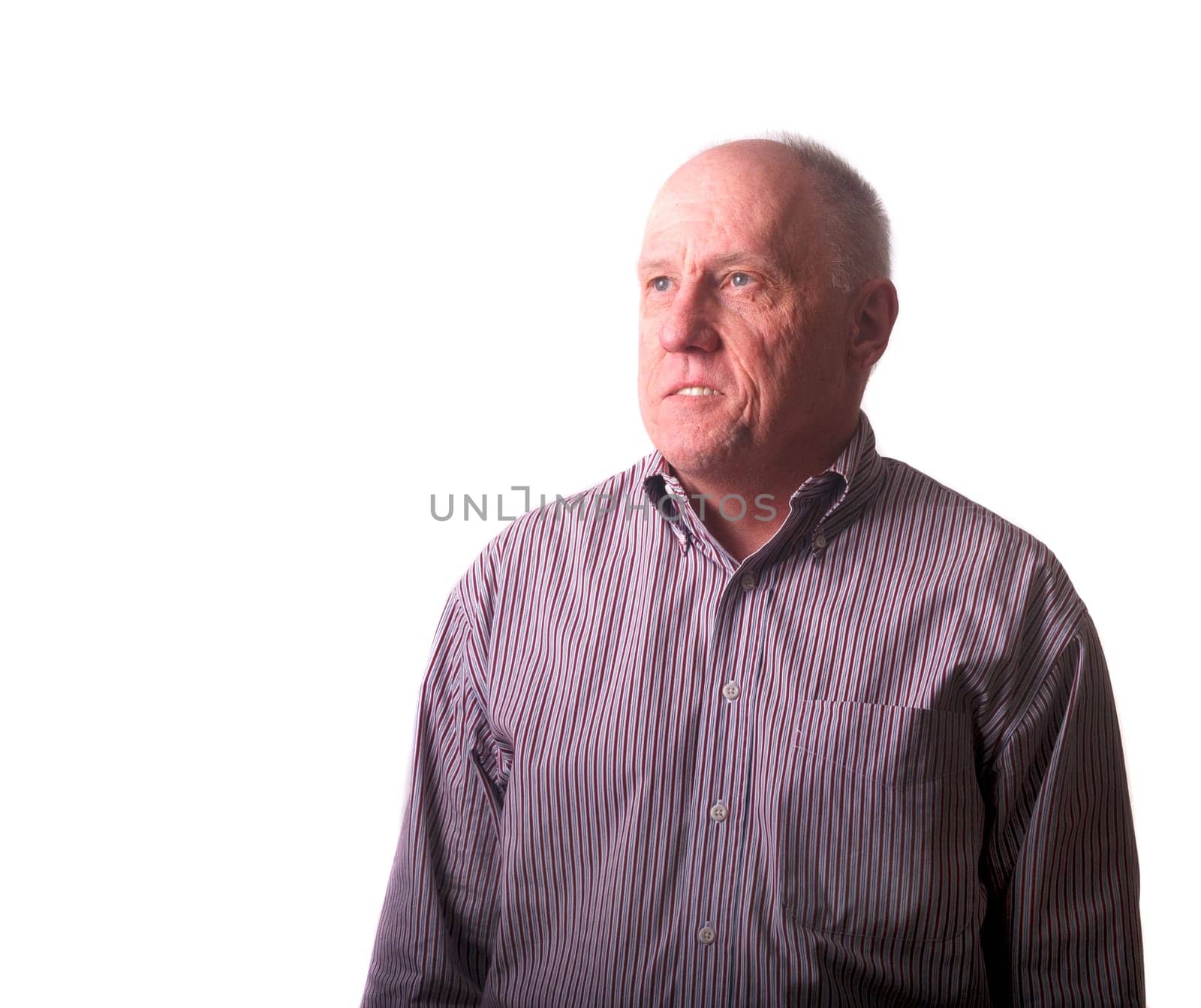 An older bald man in striped shirt looking up with hope or inspiration