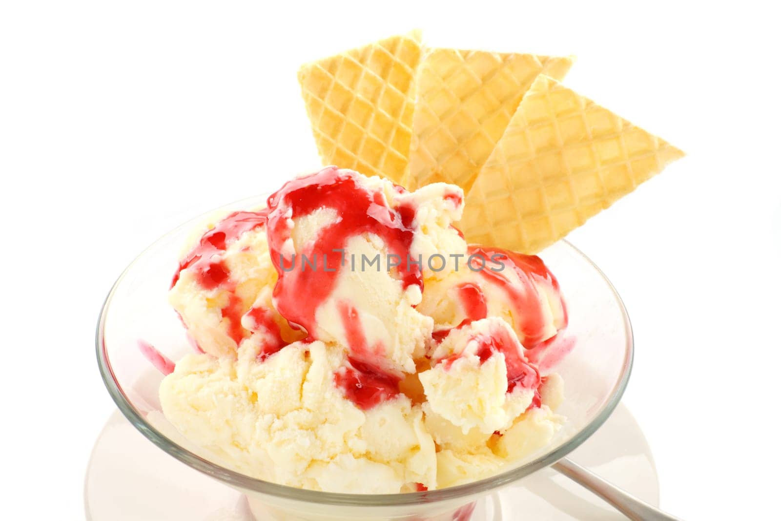 Vanilla ice cream with strawberry topping and golden wafers.
