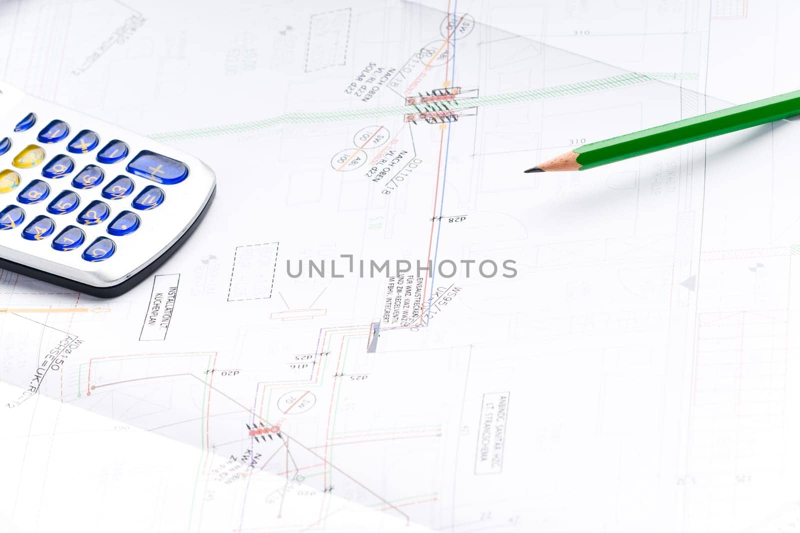 Detail of an industrial plan with green pencil and calculator