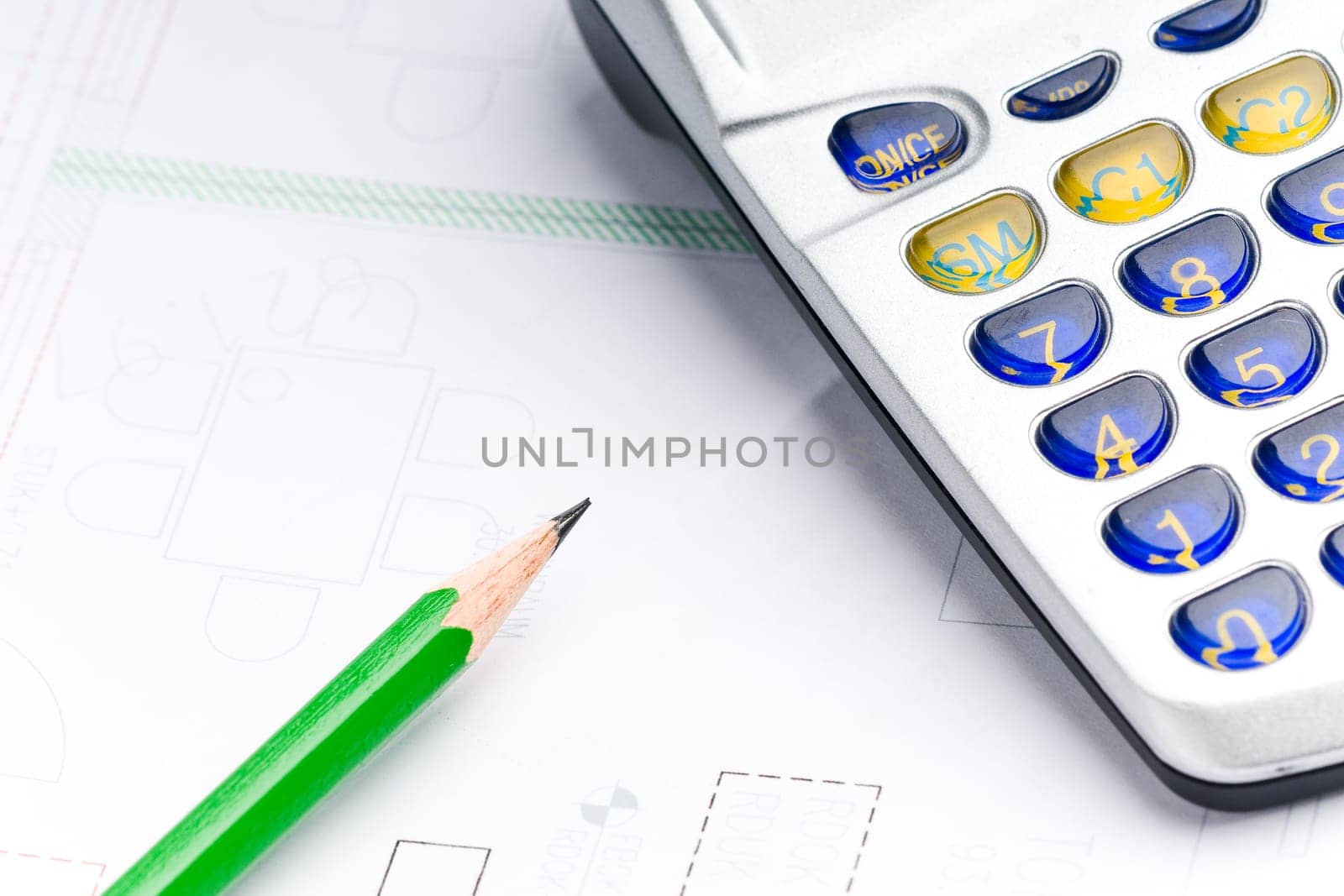 Detail of an industrial plan with green pencil and calculator