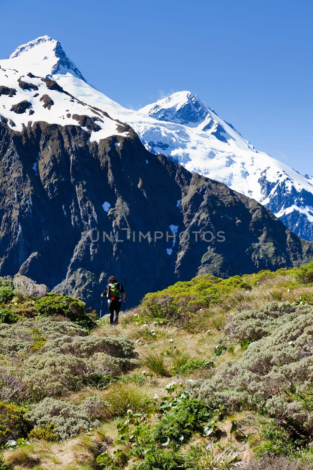 Woman hiker walking the trails looking towards the mountain tops in New Zealand