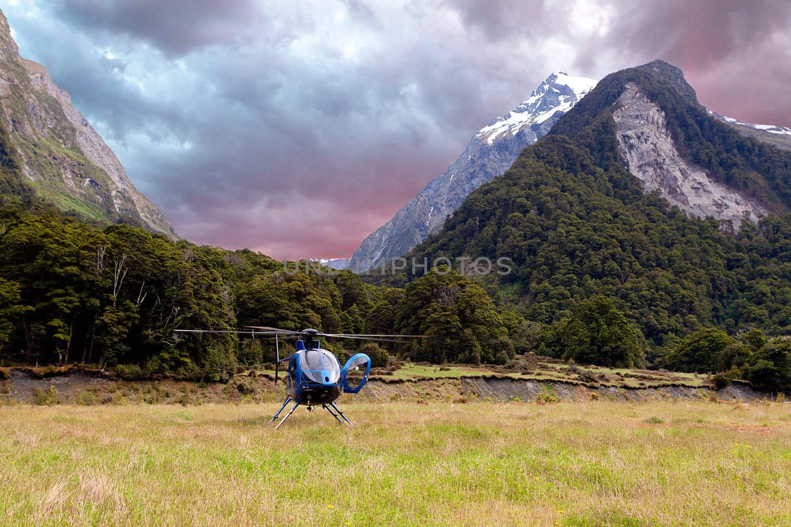 Helicopter landing in a meadow in the Wikin river valley in New Zealand