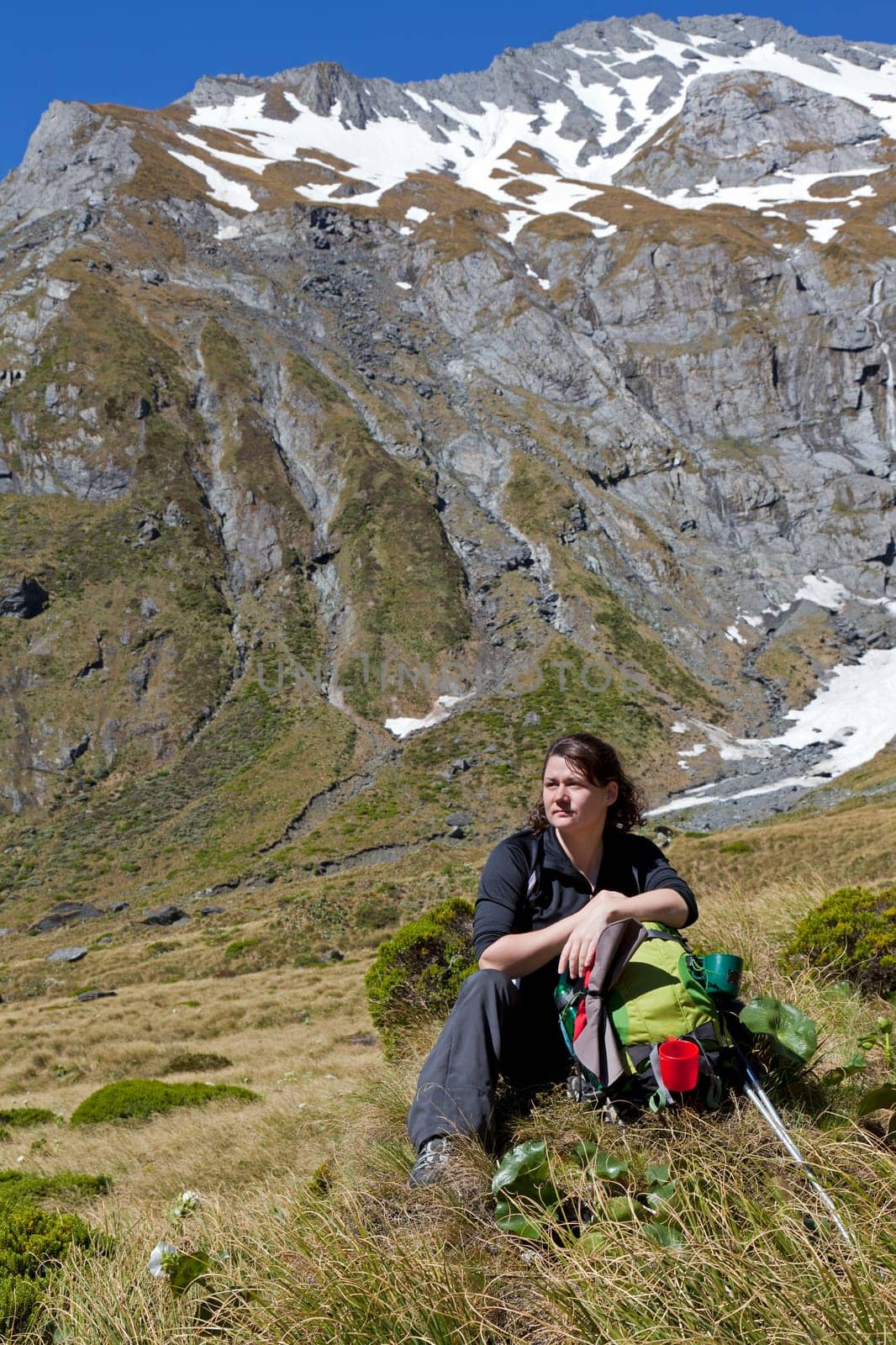 Woman hiker taking a break in the Wilkin River Valley, New Zealand
