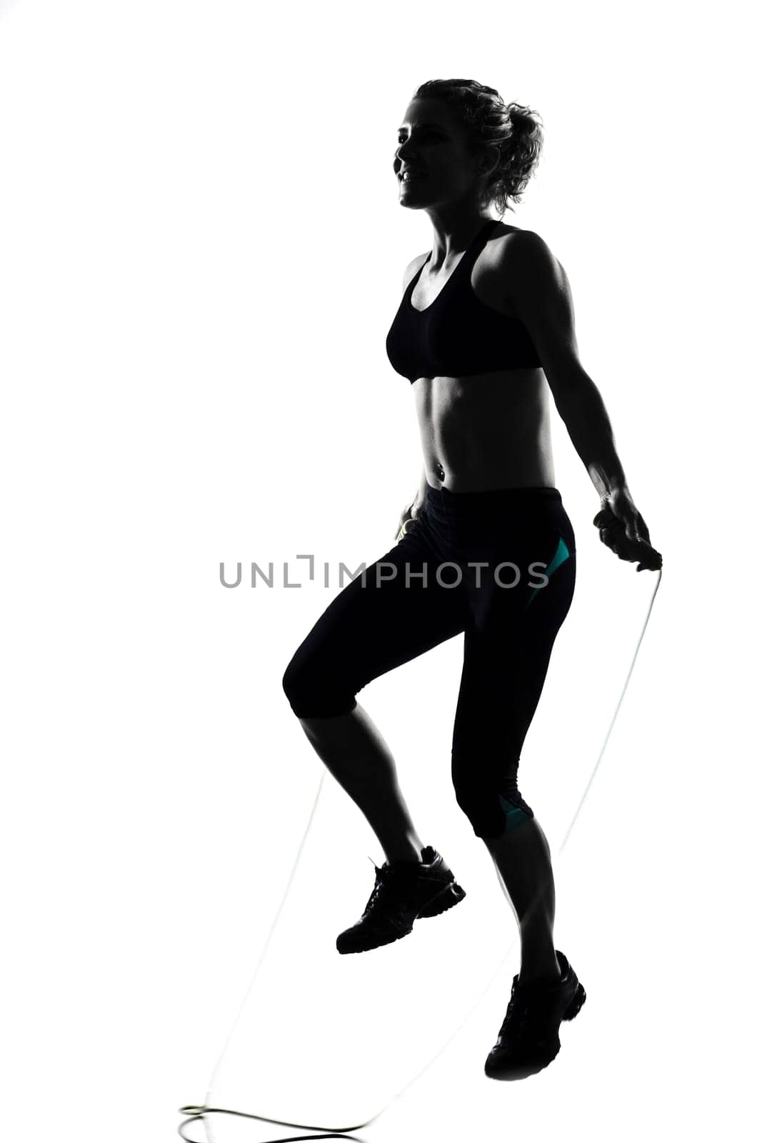 woman workout fitness posture body building jumping rope exercise exercising on studio isolated white background