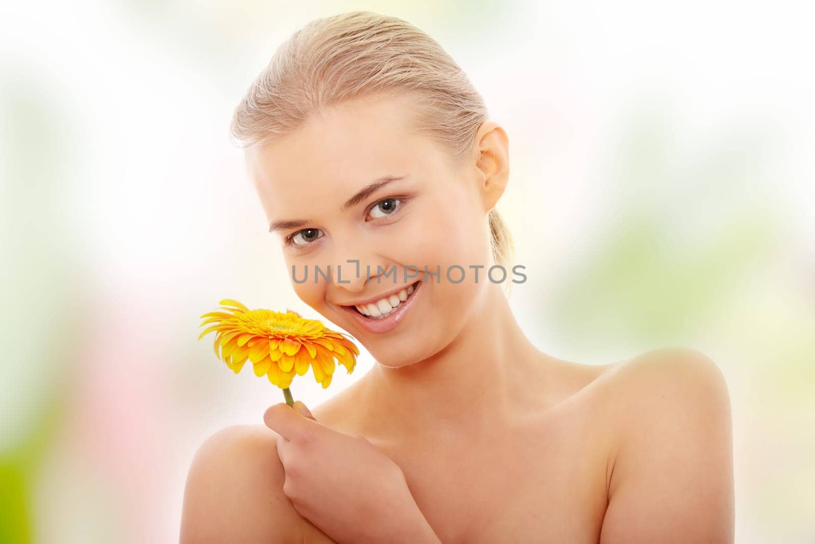 Portrait of the attractive girl without a make-up, with flower in hand