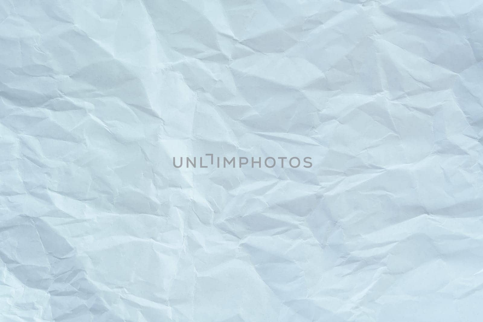 Wrinkled white paper sheet with creases and folds, creating a textured background suitable for design, mockups, or artistic projects.