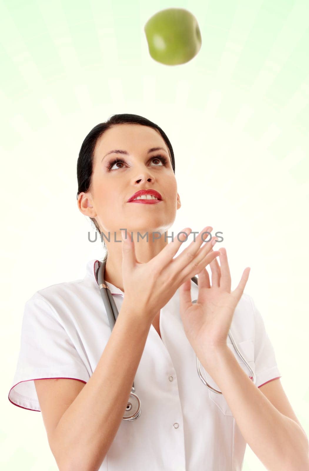 Healthy eating or lifestyle concept. Smiling woman doctor with a green apple.