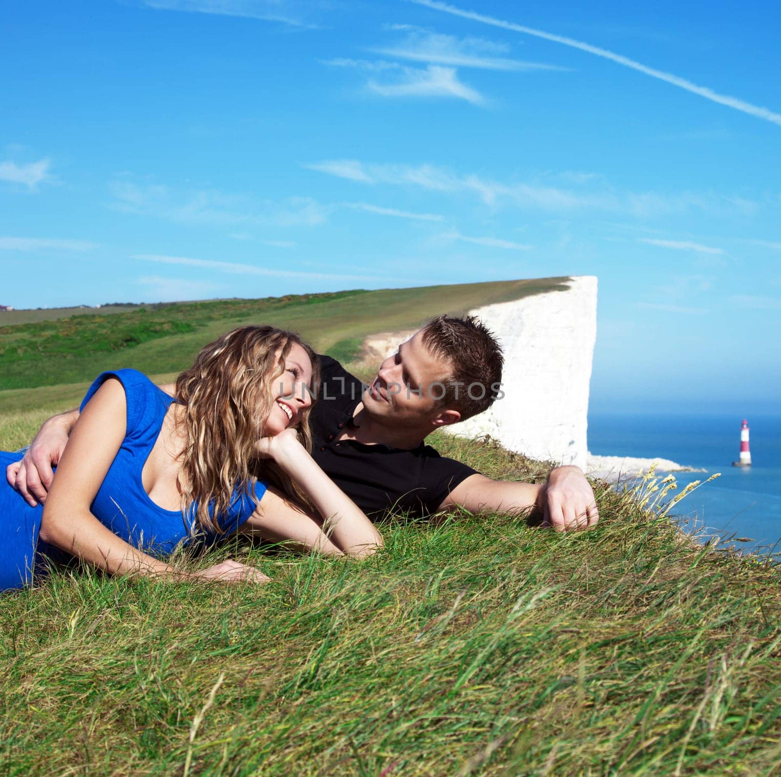 Happy couple smiling on the edge of a white cliff