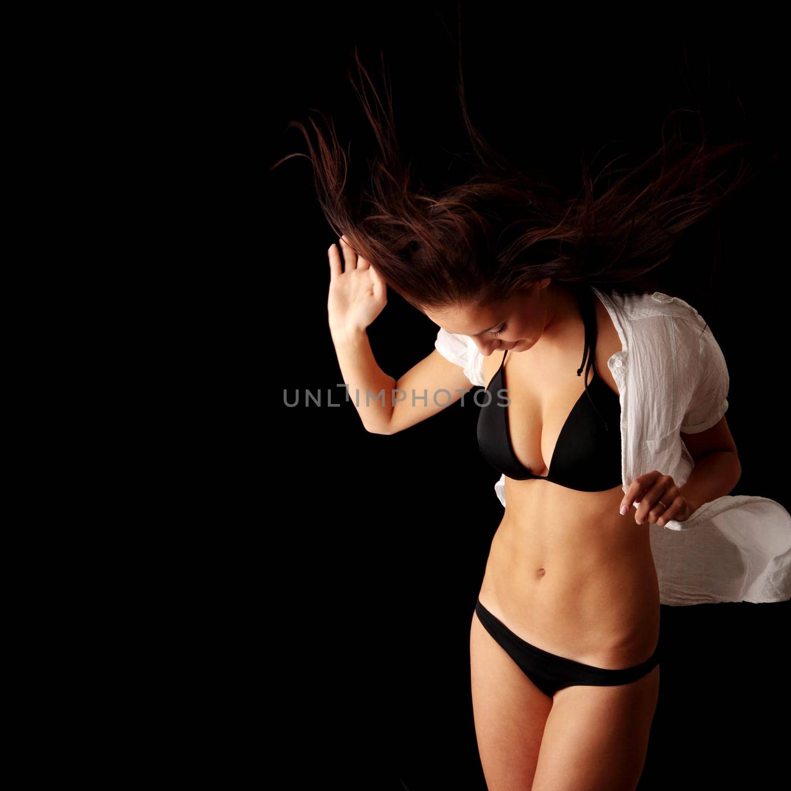 Young beautiful slim woman posing in bikini - with wind - isolated on black