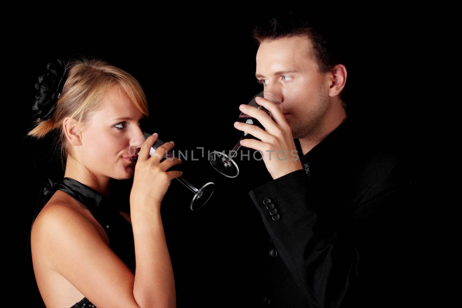 Men, women and red wine. Black background